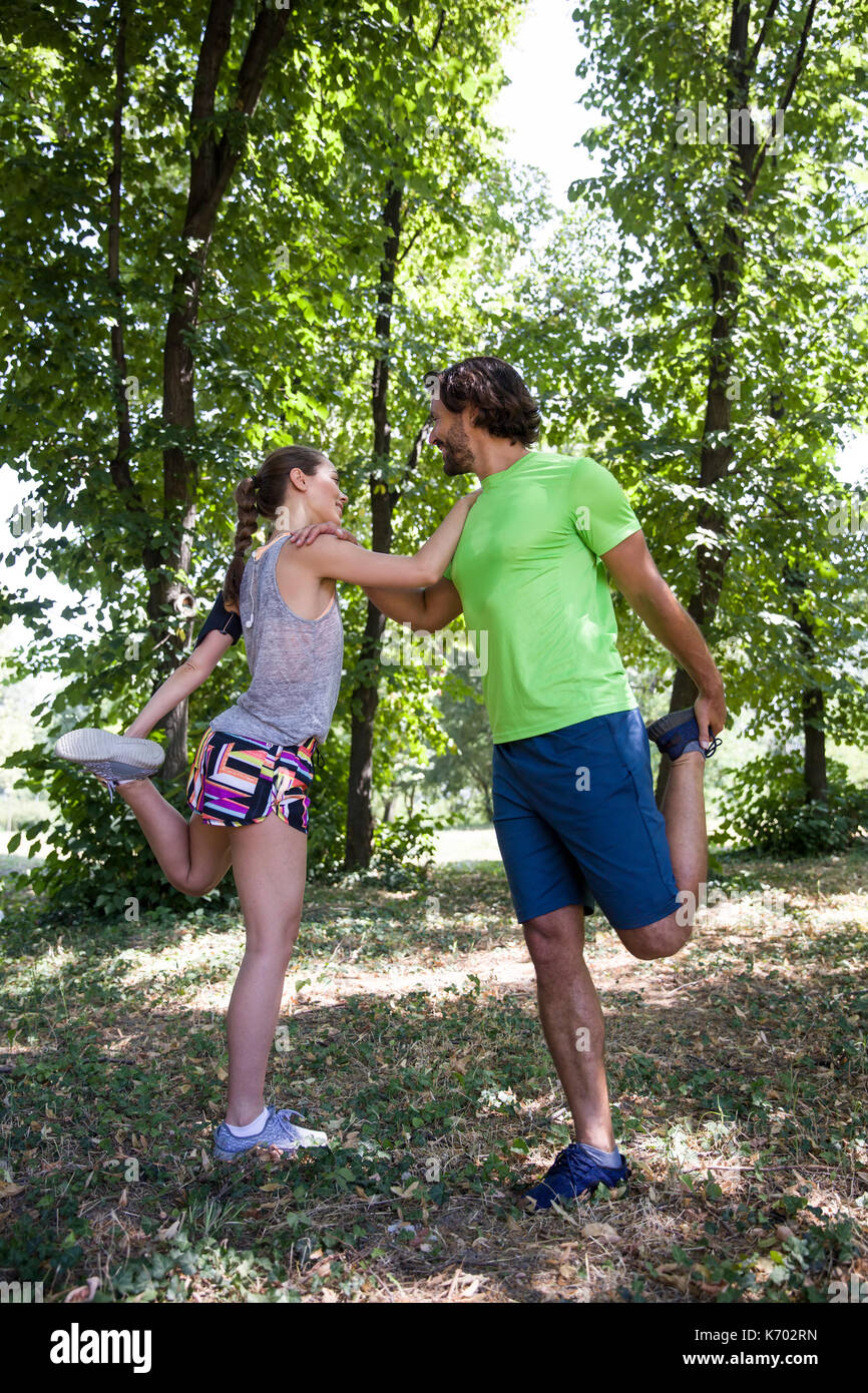 Coppia giovane avente esercizio nel parco in una giornata di sole Foto Stock