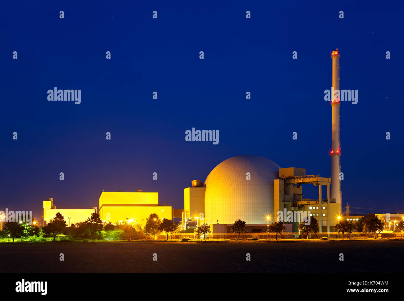 Edificio del reattore di una grande centrale nucleare con la notte blu del cielo. Foto Stock