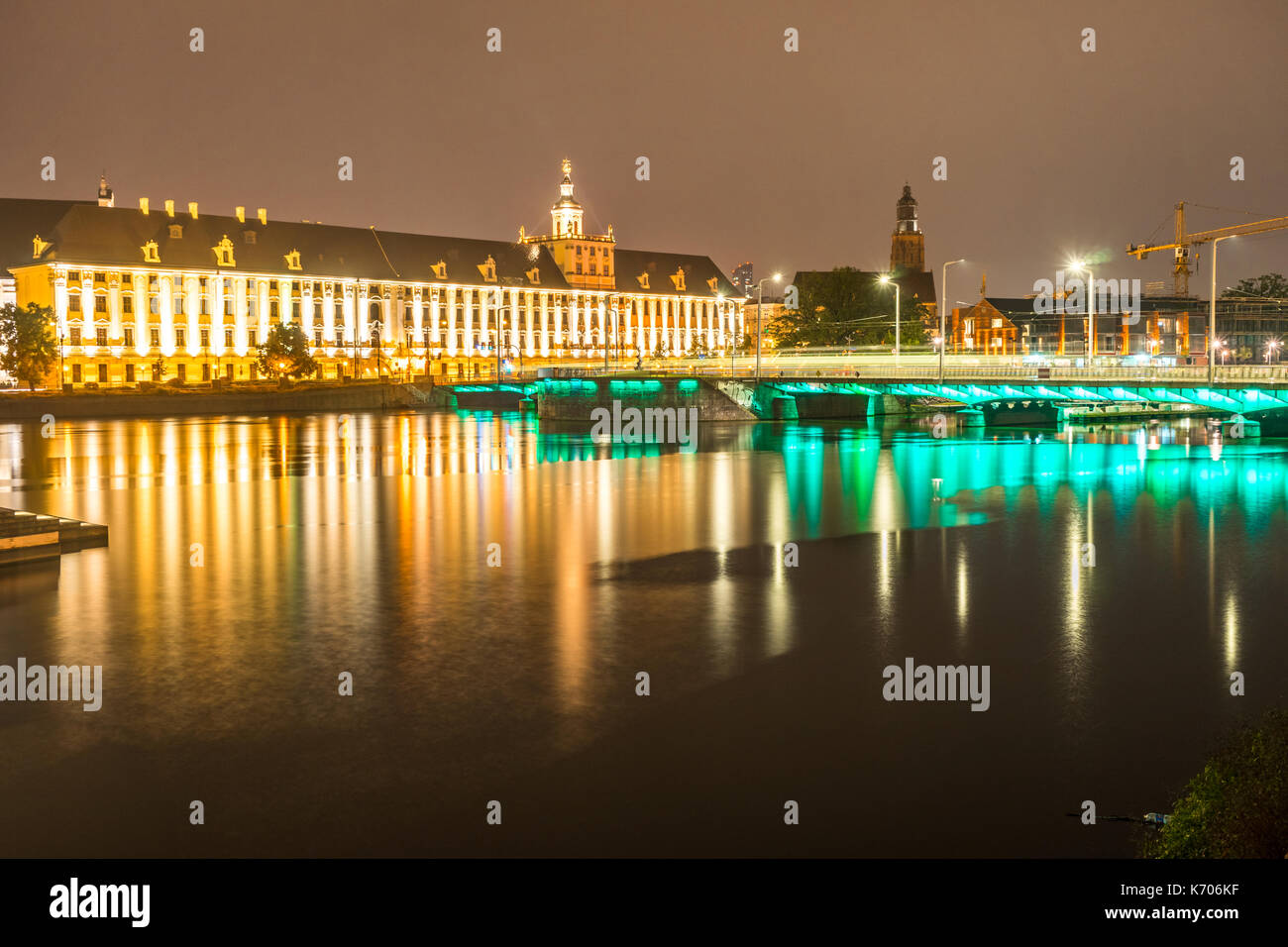 Università di Breslavia lungo le rive del fiume Oder illuminata di notte, Wroclaw, Polonia Foto Stock