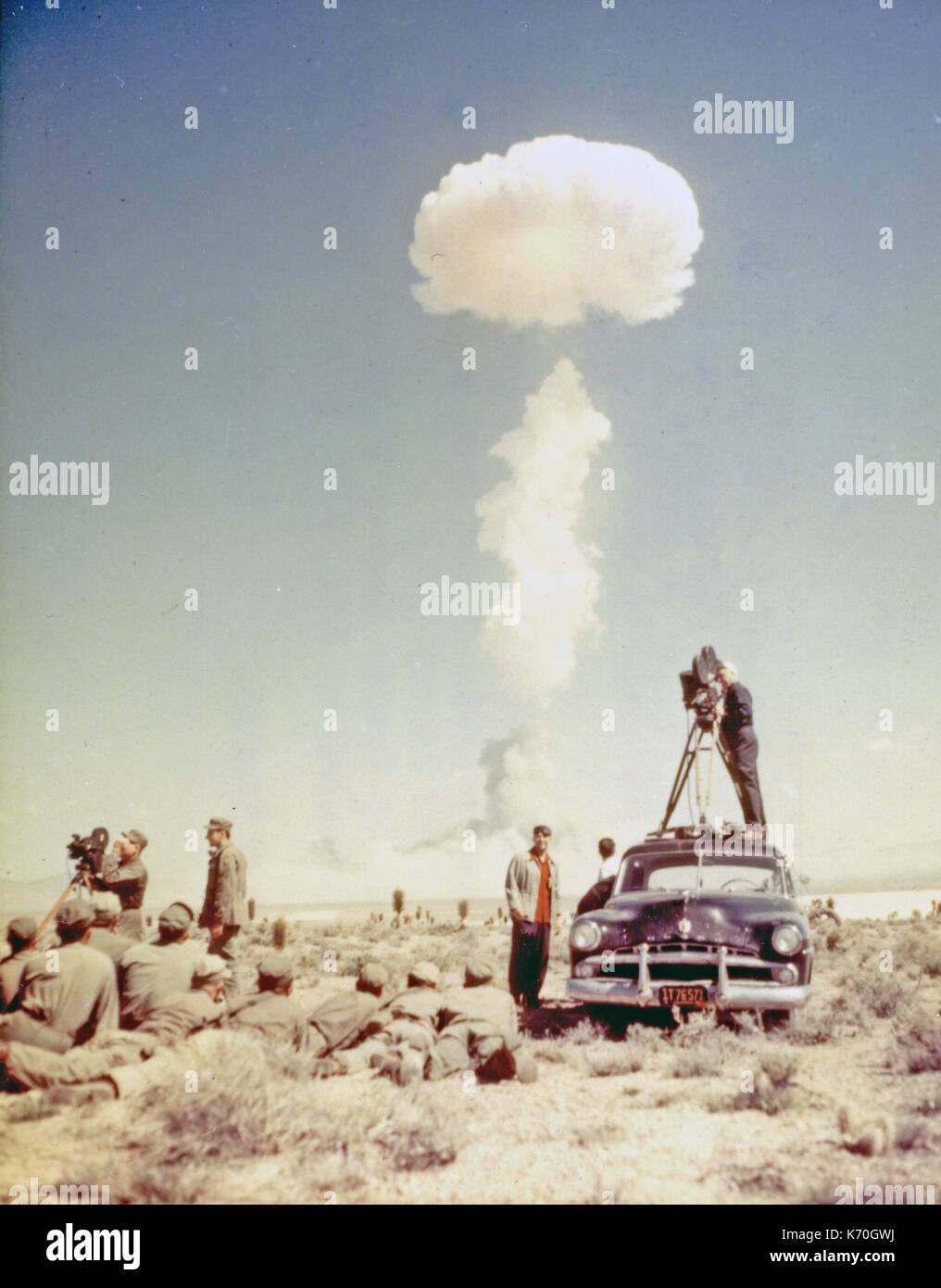 Aprile 22, 1952, Yucca Flats, Nevada - Columbia Broadcasting System TV Cinegiornale cameraman truppe e la visione di una prova di esplosione di una bomba atomica. Foto Stock