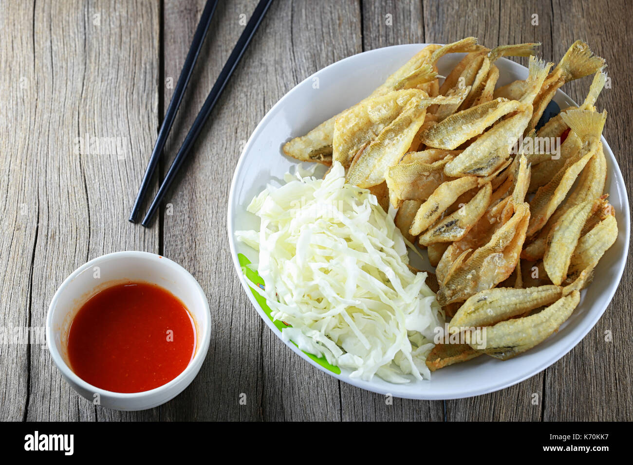 Argento o sillago sillaginidae di pesce fritto nel piatto sul pavimento in legno si tratta di un locale thailandese cibi in popolari. Foto Stock