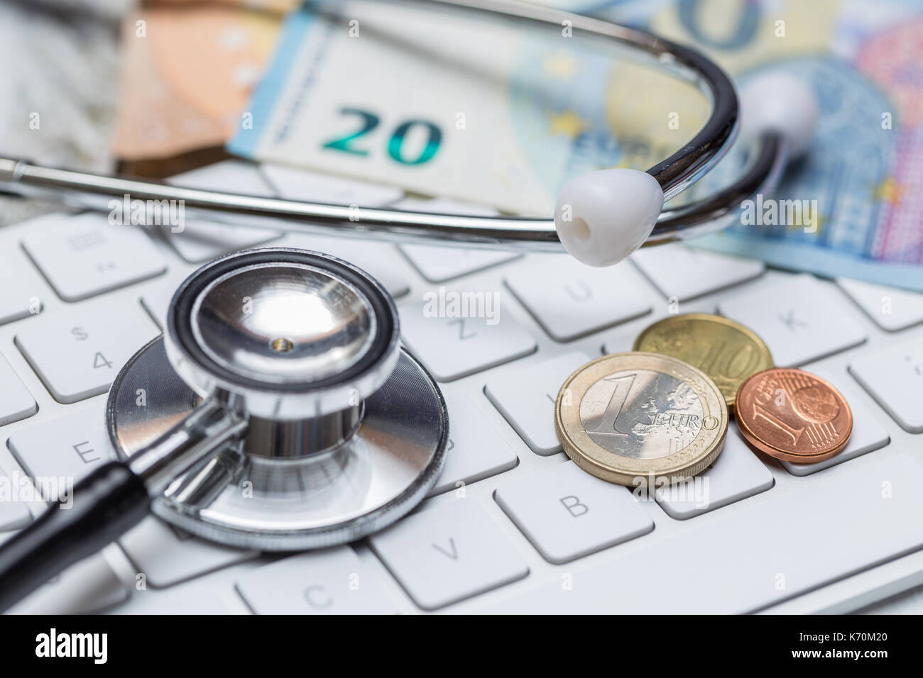 Lo stetoscopio e tastiera con monete e il concetto di denaro. Foto Stock