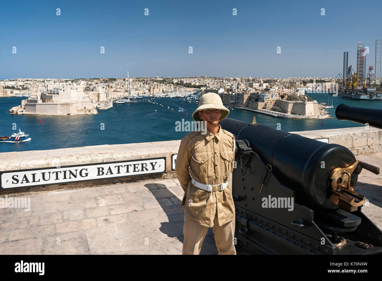 Operatore in uniforme del cannone di mezzogiorno alla batteria a salve a La Valletta, Malta. Foto Stock