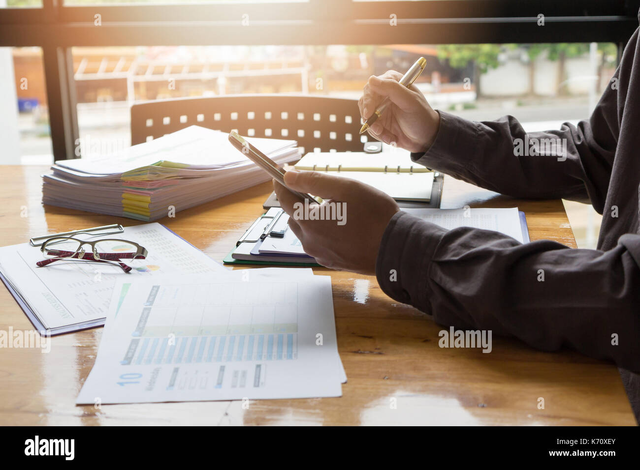 Affari e finanza concetto di ufficio a lavorare, imprenditore utilizza lo smartphone per calcolare e discutere di diagramma di analisi Foto Stock