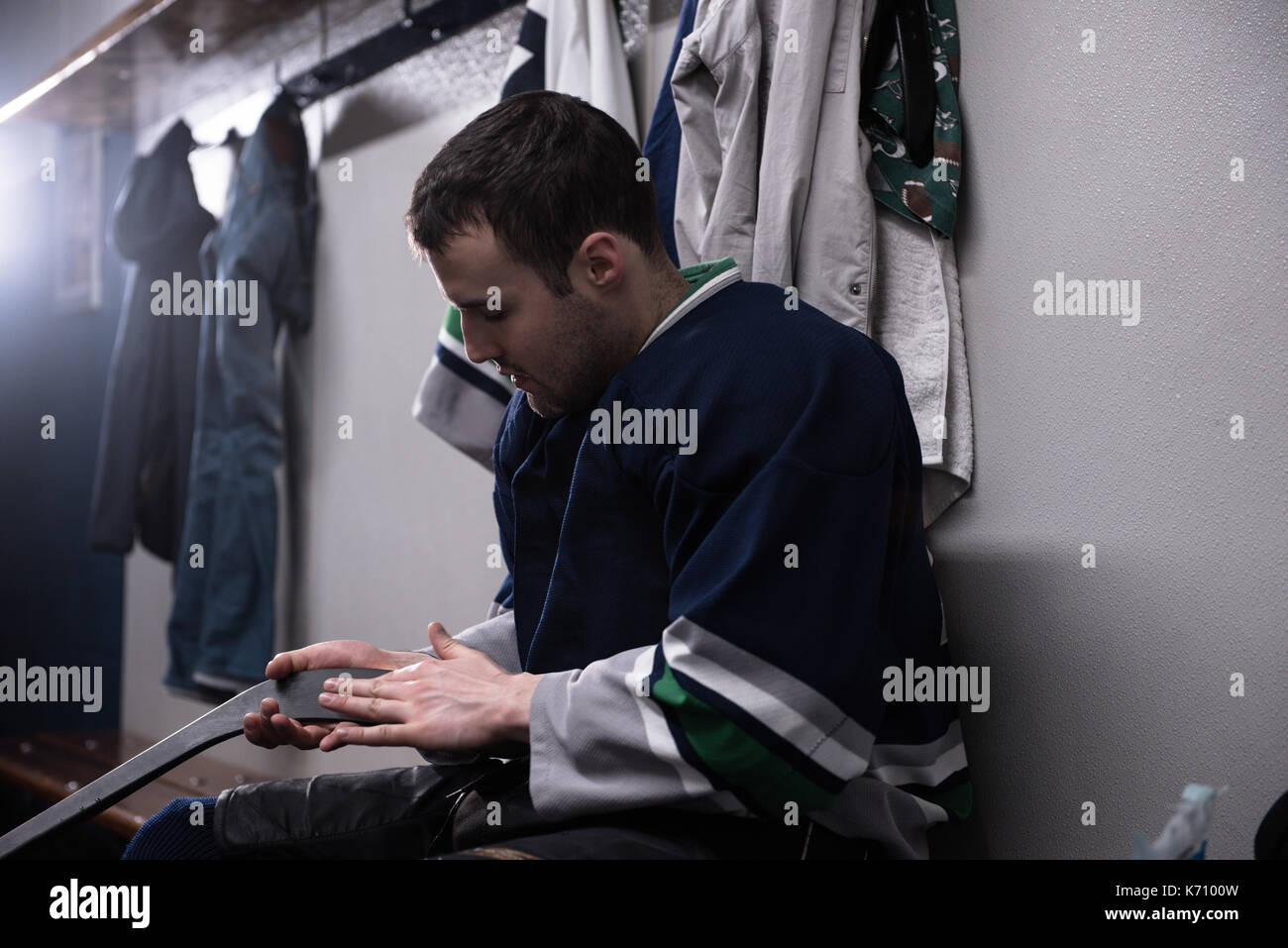 Maschio di giocatore di hockey su ghiaccio in stick Locker room Foto Stock