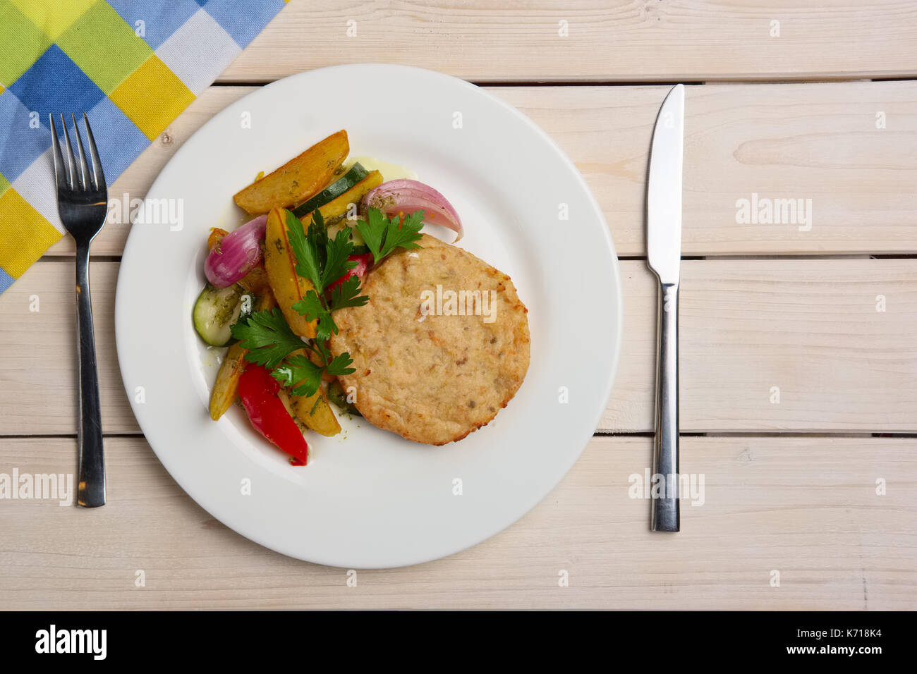 Cotoletta di pesce alla griglia con patate, cipolle, peperoni e zucchine Foto Stock