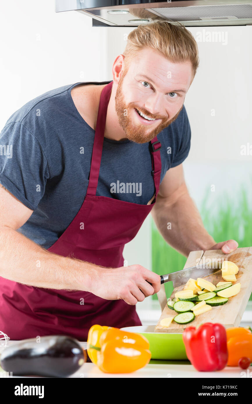 L'uomo la preparazione di un alimento sano per la cottura in cucina Foto Stock