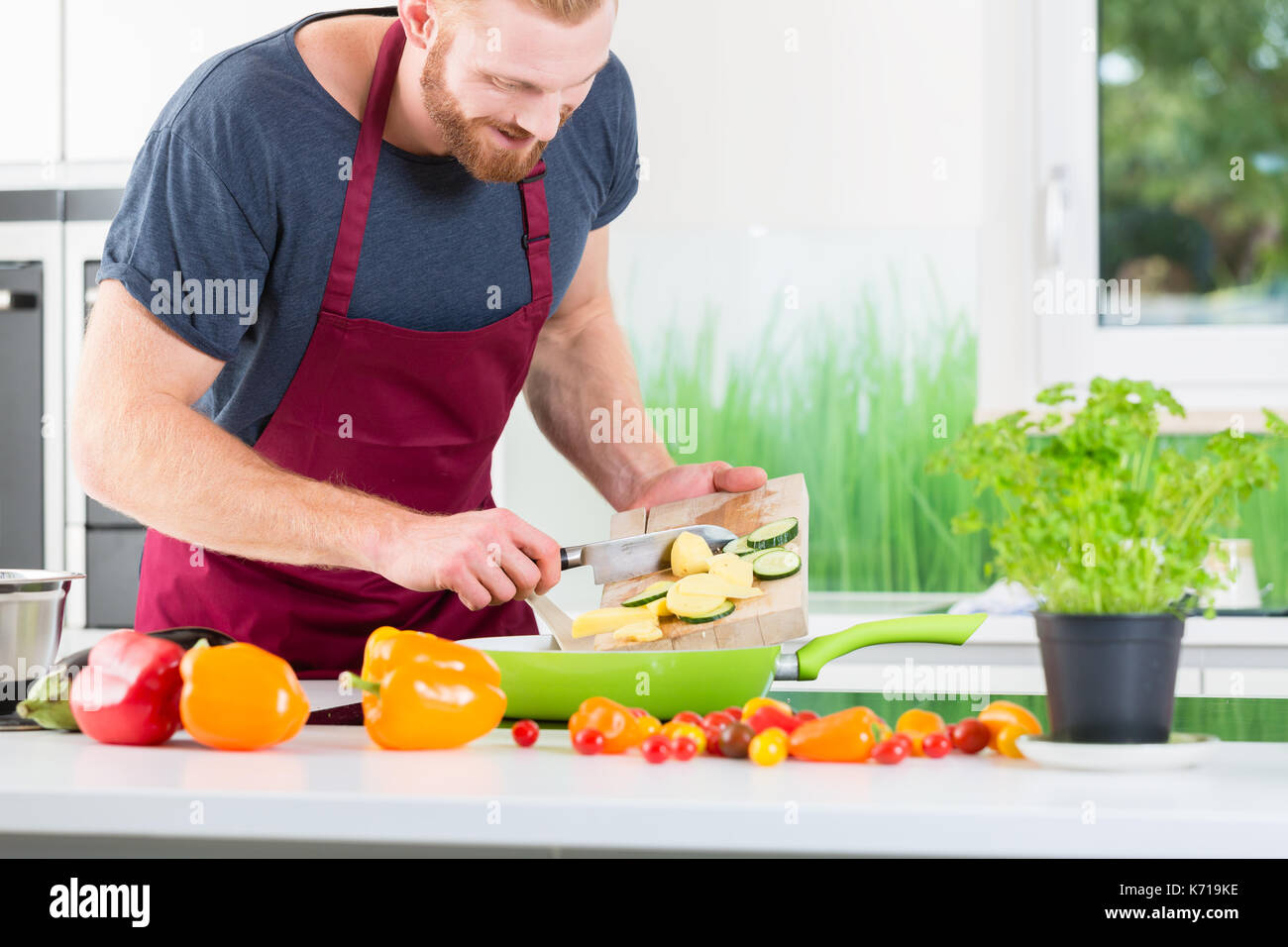 L'uomo preparare molto sano cibo biologico per la cottura in cucina Foto Stock