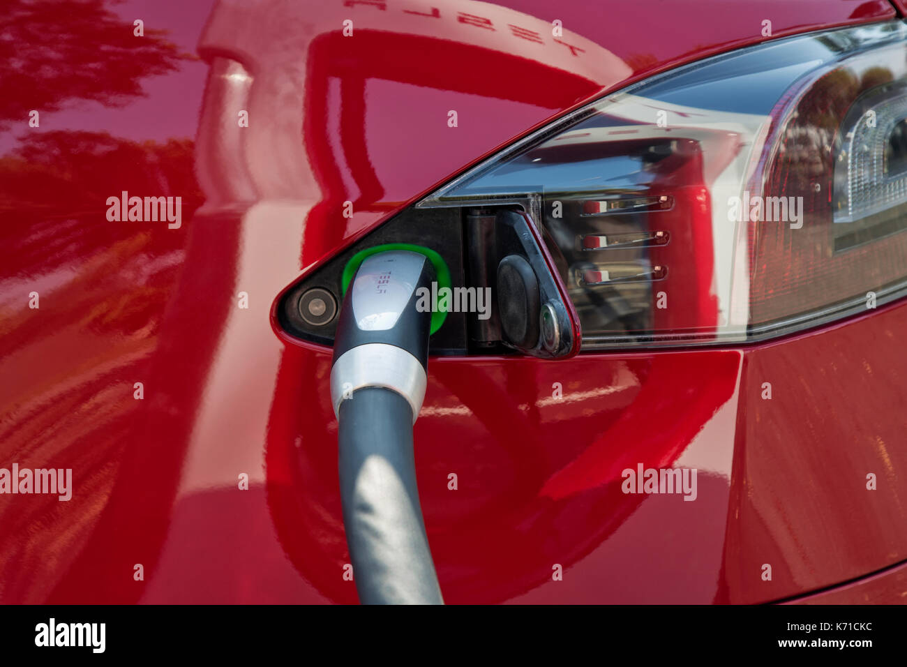 Tesla 'S' Sedan collegato a 480 volt (ricarica rapida) Supercharger Station, collegato il cavo. Foto Stock