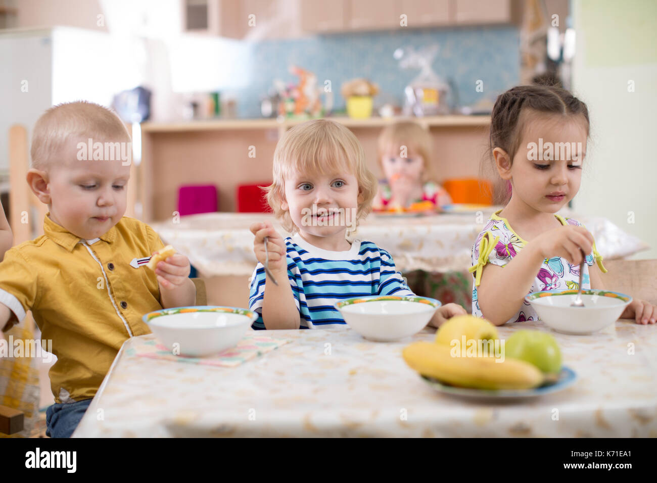 Gruppo di bambini a mangiare in una scuola materna Foto Stock