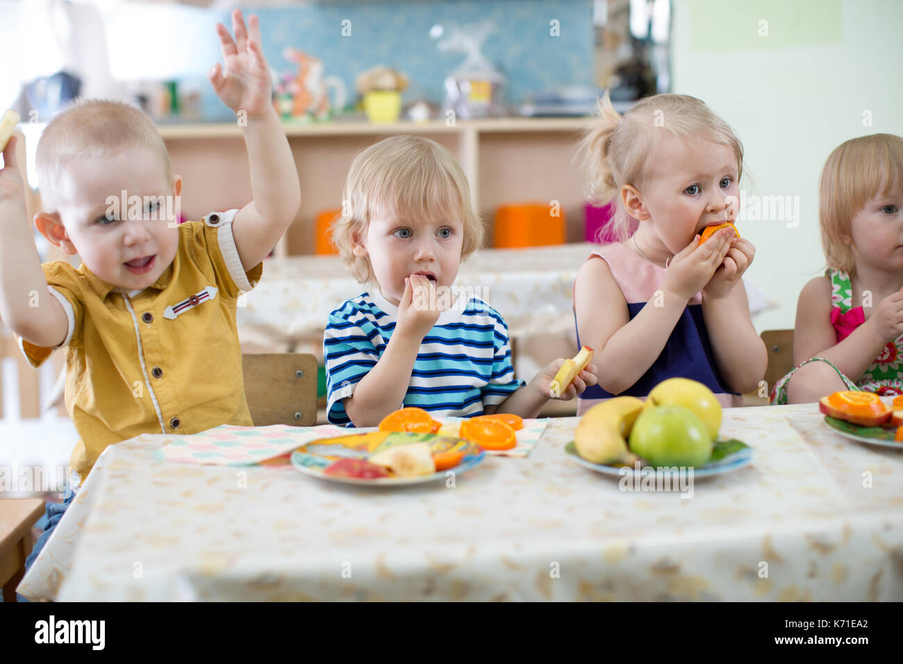 Gruppo di bambini a mangiare in una scuola materna Foto Stock