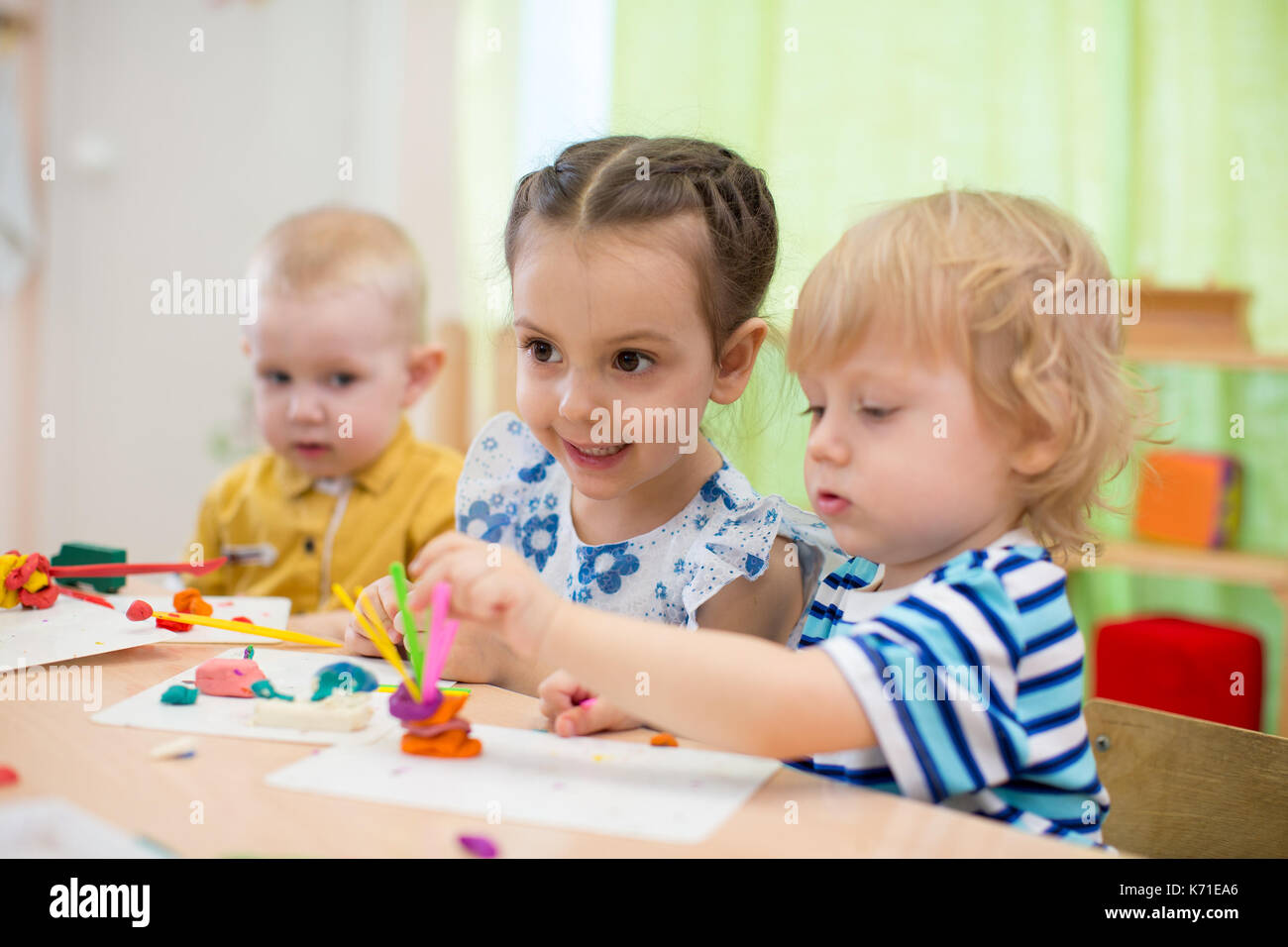La modellazione per bambini o la riproduzione in una scuola materna con interesse Foto Stock