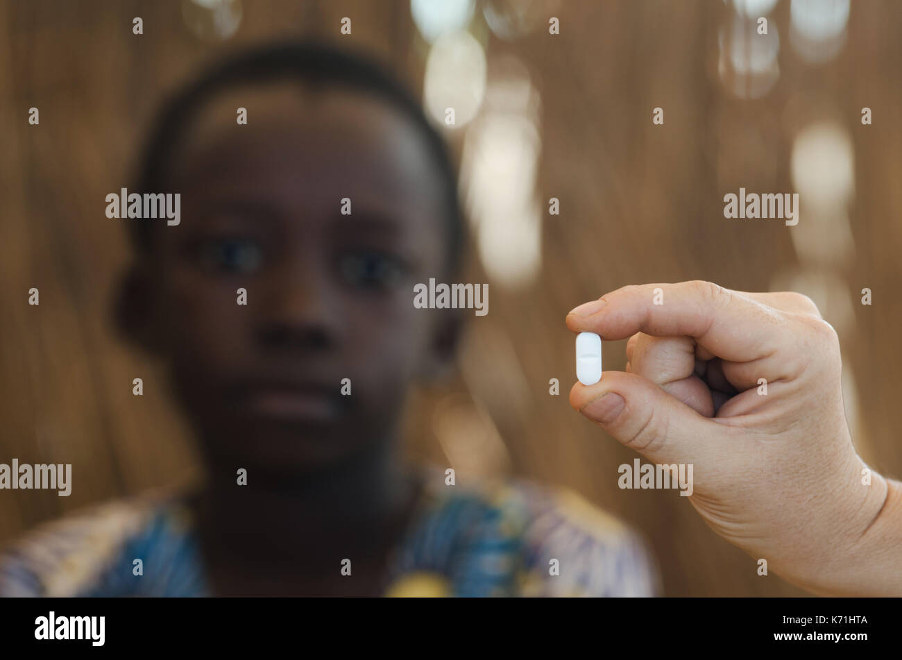 Giovane ragazzo africano come ottenere una pillola di medicina da parte di un medico di bianco Foto Stock