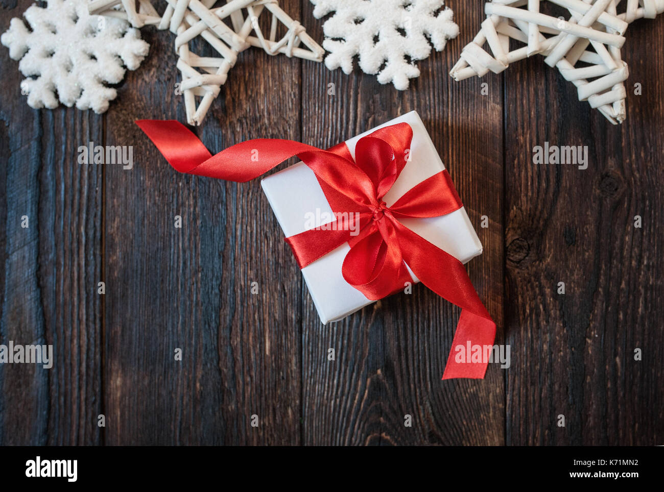 Confezione regalo con nastro rosso su uno sfondo di legno Foto Stock