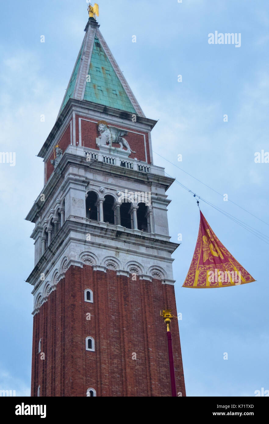 Il tradizionale fine del Carnevale veneziano, segnato dal sollevamento del rosso veneziano e bandiera gialla fino al Campanile di San Marco, Venezia Foto Stock