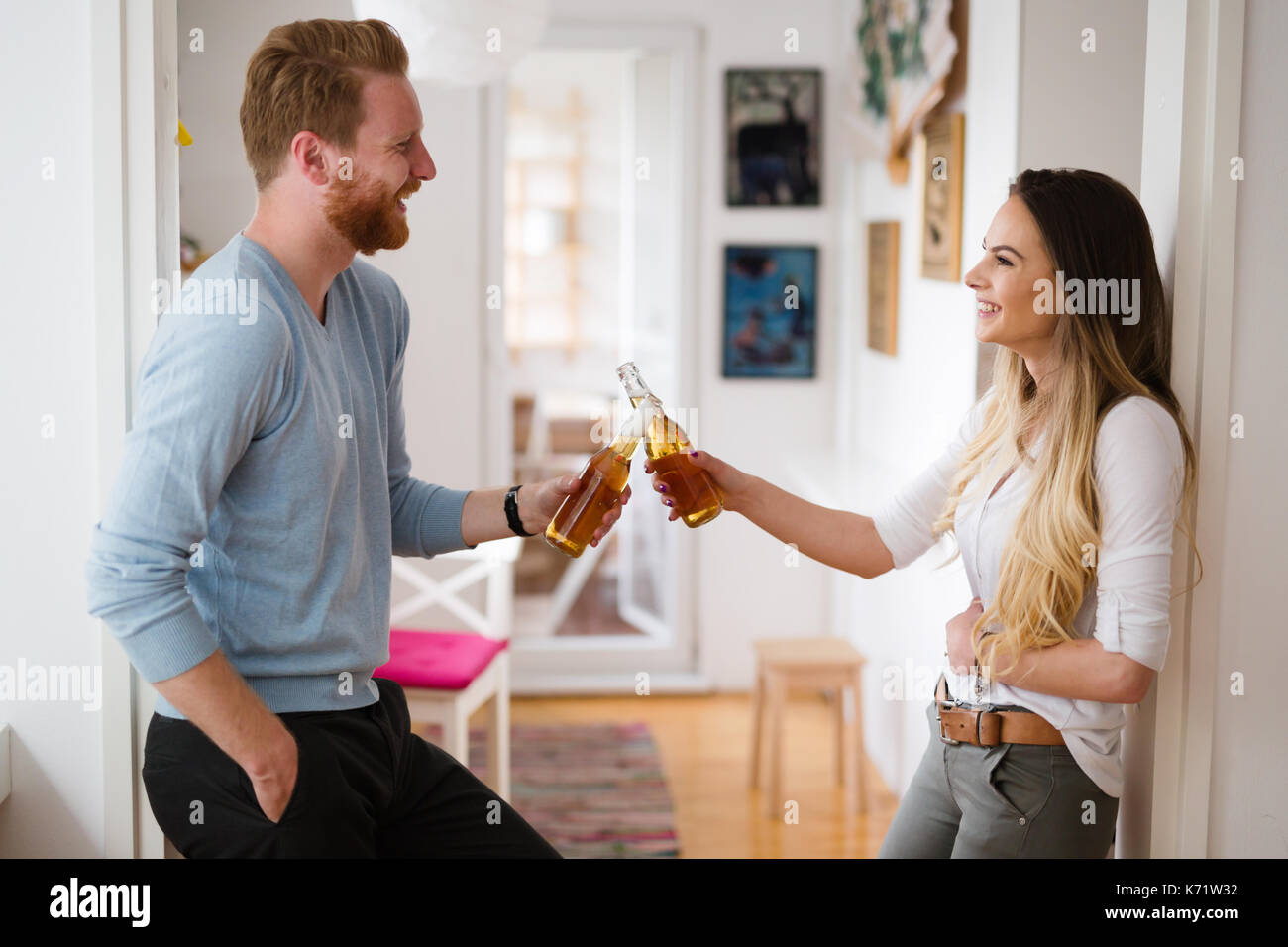 Coppia felice di bere birra e tostatura a casa Foto Stock