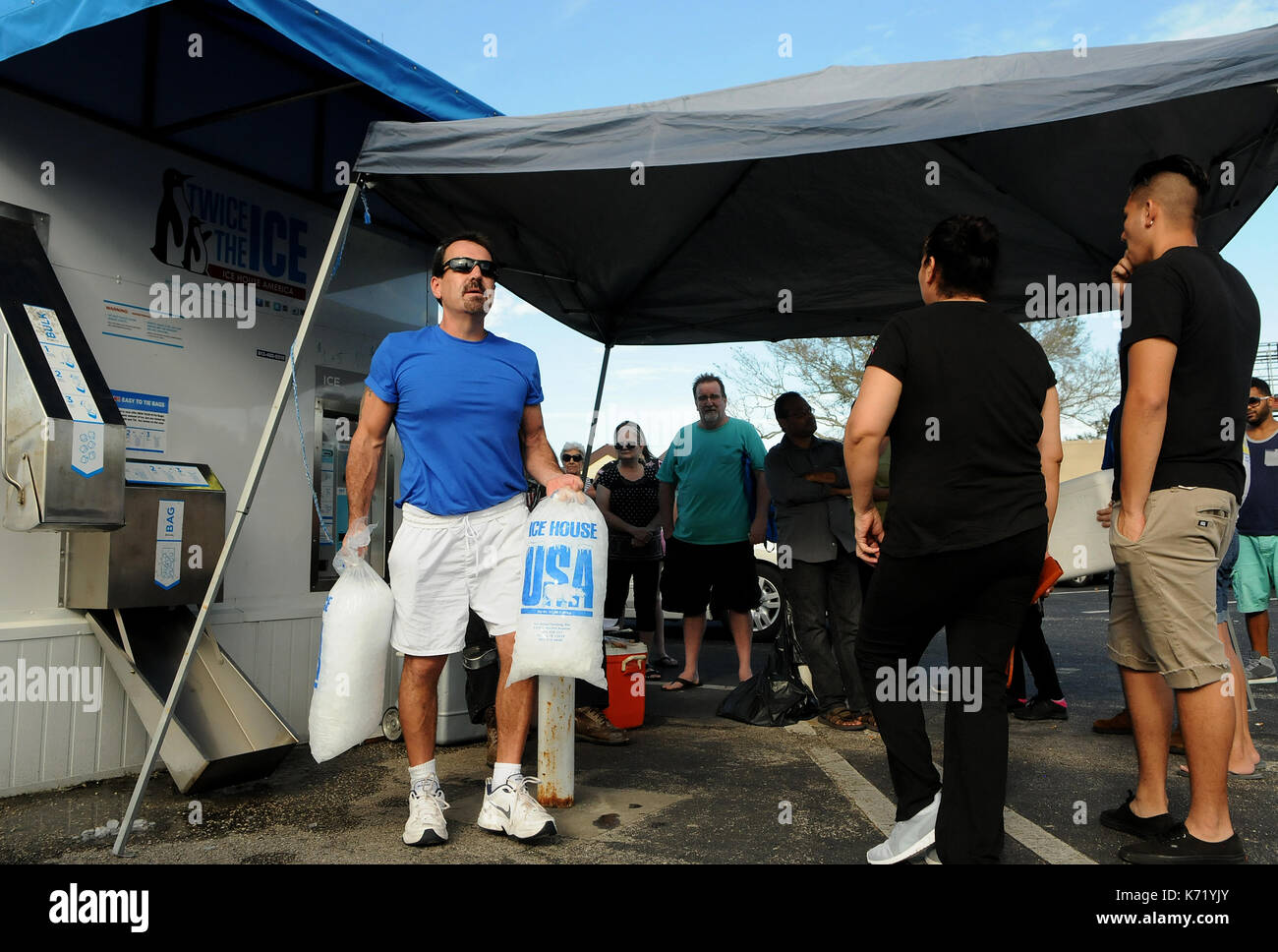 Elfers, Stati Uniti. Xiii Sep, 2017. 13 settembre 2017- elfers, Florida, Stati Uniti - dj baker porta dei sacchetti di ghiaccio ha acquistato da un distributore automatico per la sua auto il 13 settembre 2017 in elfers, Florida. con milioni di residenti in Florida ancora senza alimentazione tre giorni dopo l uragano irma colpo di stato, ghiaccio è diventato un bene prezioso e le carenze che si sono verificati a causa di un numero di fabbriche di ghiaccio in alto e in basso lo stato fosse arrestato dall'uragano. Credito: Paul Hennessy/alamy live news Foto Stock