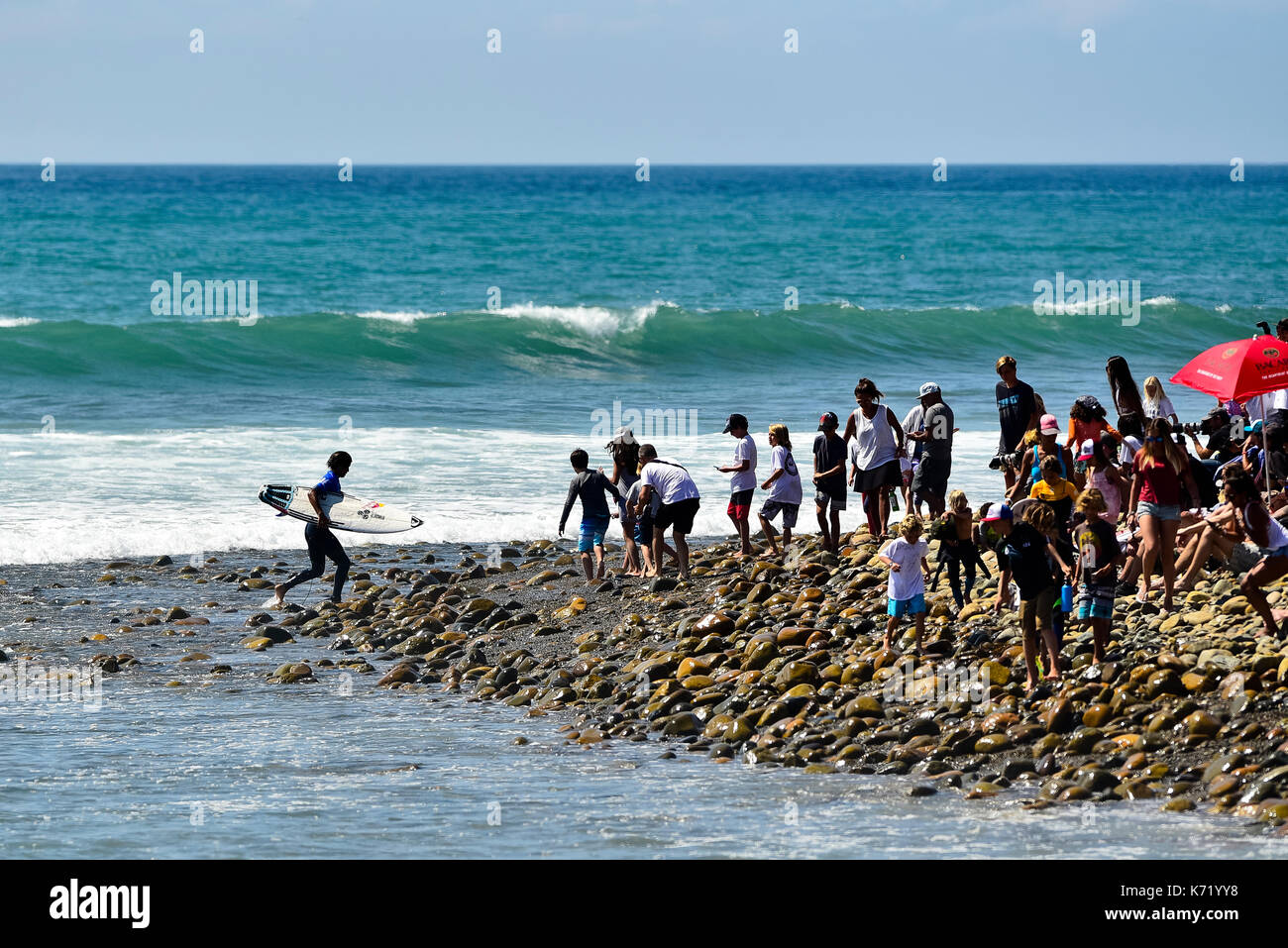 San Clemente, STATI UNITI D'AMERICA. 13 Settembre, 2017. Surfer Kanoa Igarashi (USA) con cautela scavalca la parte esposta del ciottolo reef verso tifosi impazienti afer il suo calore contro l'ex campione del mondo Mick Fanning (AUS) durante il 2017 Hurley Pro surf contest in basso a tralicci, San Onofre State Park, CA. Surfer: Kanoa Igarashi (USA). Credito: Benjamin Ginsberg/Alamy Live News. Foto Stock