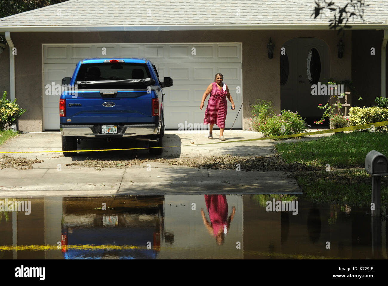 Altamonte Springs, Stati Uniti. Xiv Sep, 2017. 14 settembre 2017- Altamonte Springs, in Florida, Stati Uniti - una donna e un carrello sono visto riflesso in acque di esondazione in strada nella primavera oaks quartiere di Altamonte Springs, in Florida, il 14 settembre 2017. Gli operatori di emergenza barche usate e camion per il soccorso di più di 50 residenti su Settembre 11, 2017 quando l'acqua dalle vicinanze del piccolo fiume wekiva inondato le loro case dopo il passaggio dell uragano irma. Credito: Paul Hennessy/alamy live news Foto Stock