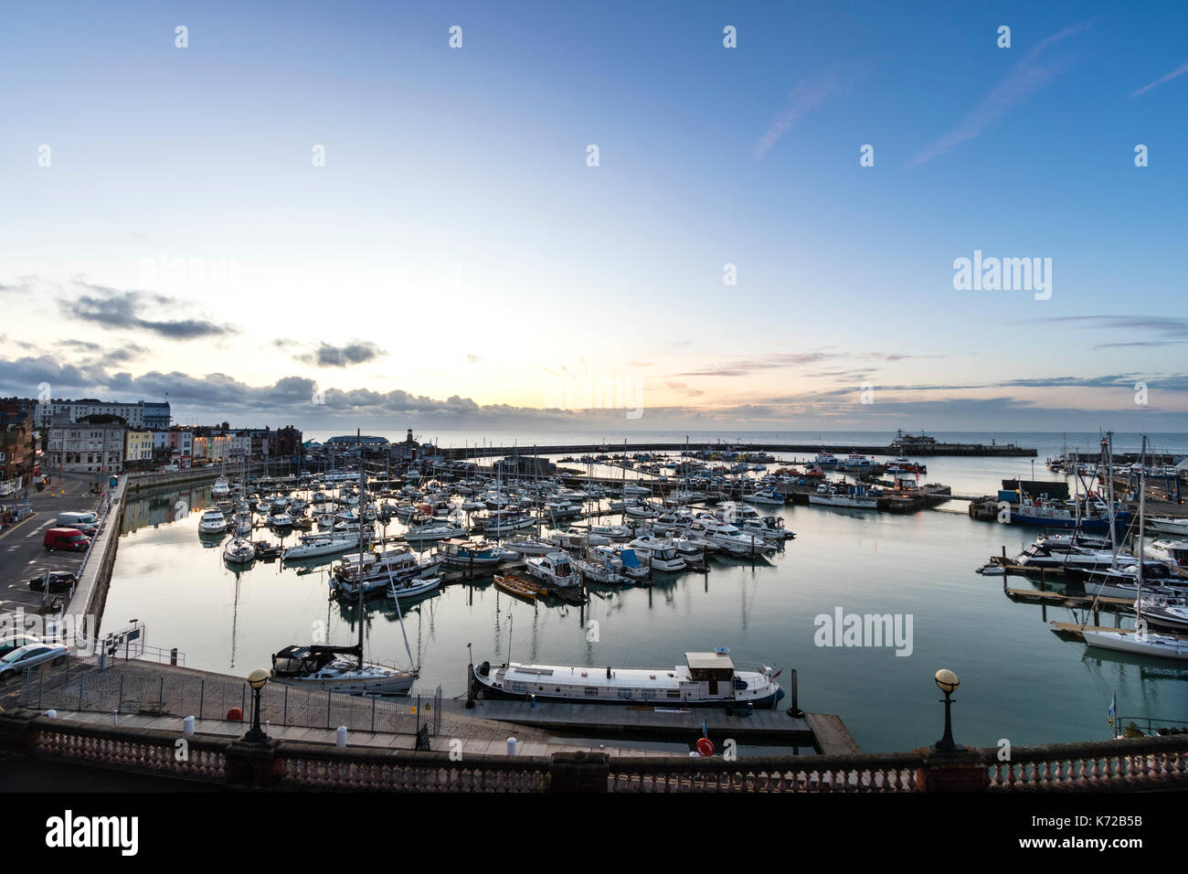 Inghilterra, Ramsgate. Dawn sky a rottura di giorno oltre il Canale della Manica e il Royal Ramsgate Porto. Il marina Yachting in primo piano. Cielo blu chiaro. Foto Stock