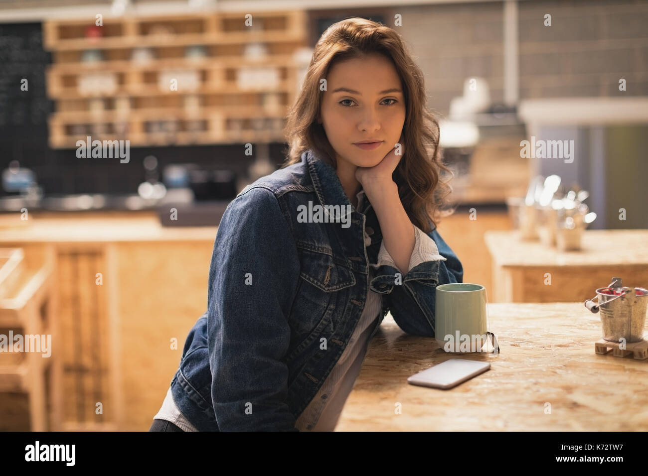 Bella donna seduta in cafÃƒÂ© con caffè sul tavolo Foto Stock
