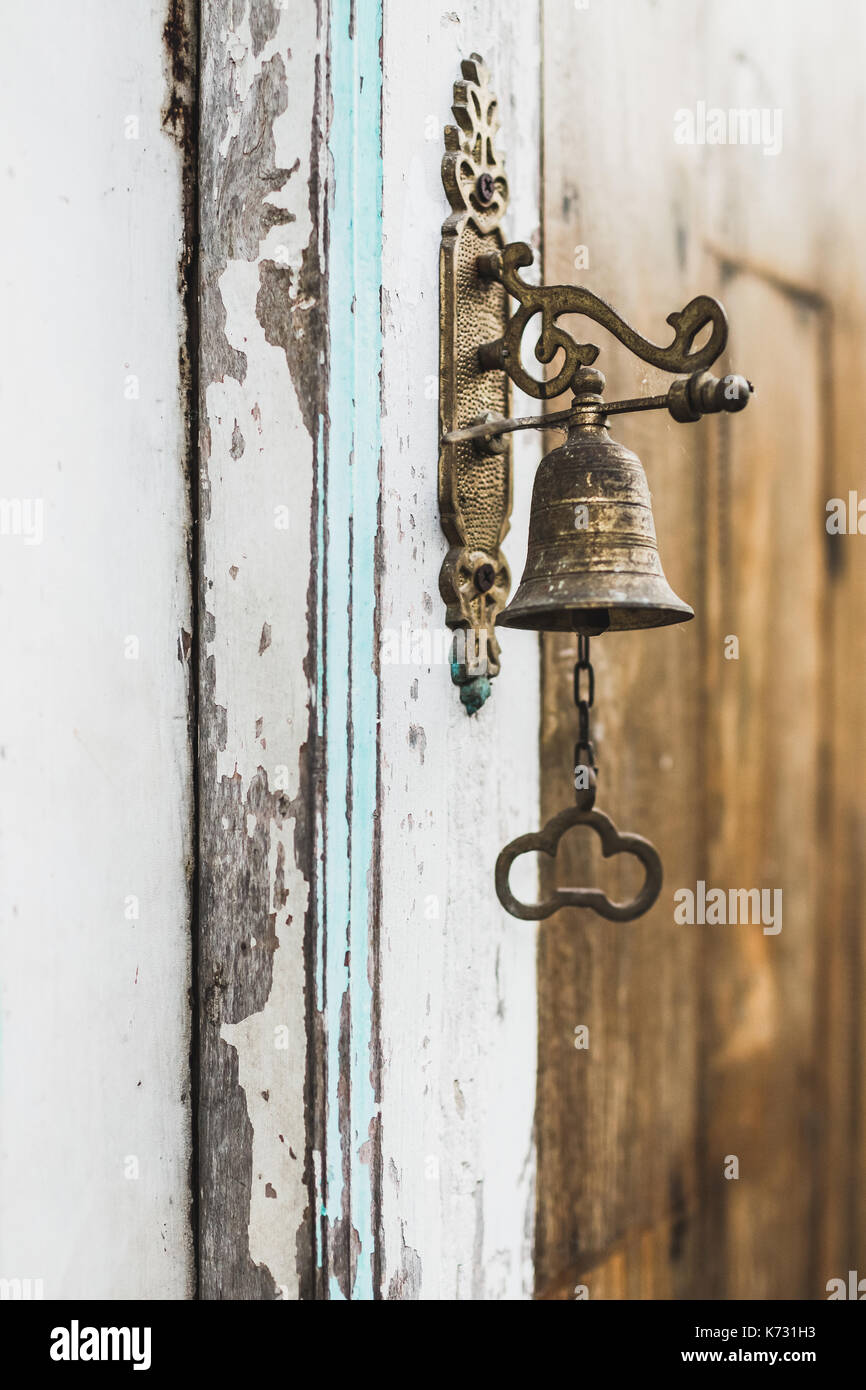 Wintage porta di bronzo sulla campana di legno porta squallido Foto Stock