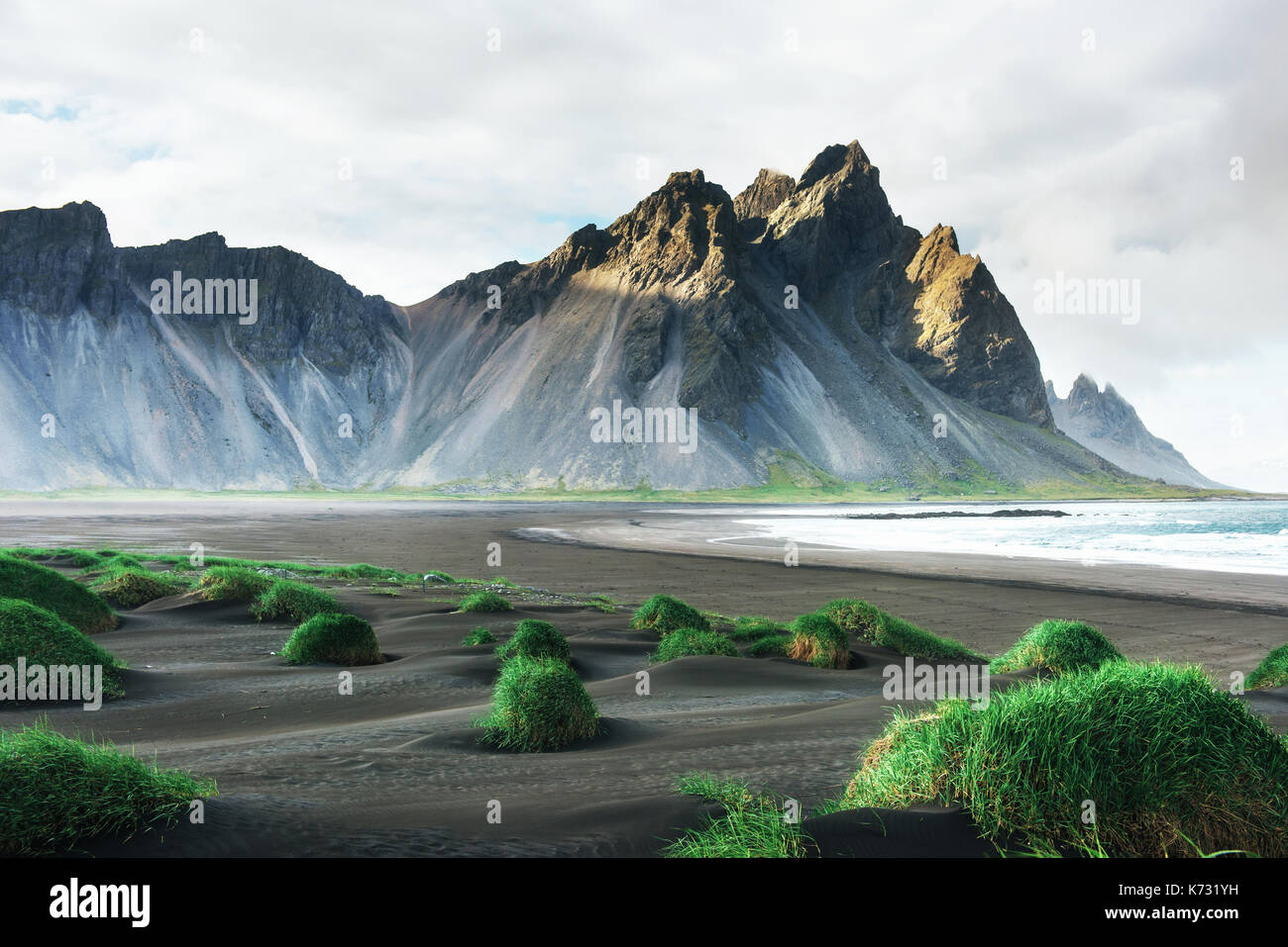 Fantastico ovest della montagna e lava vulcanica dune di sabbia sulla spiaggia stokksness, Islanda. Foto Stock