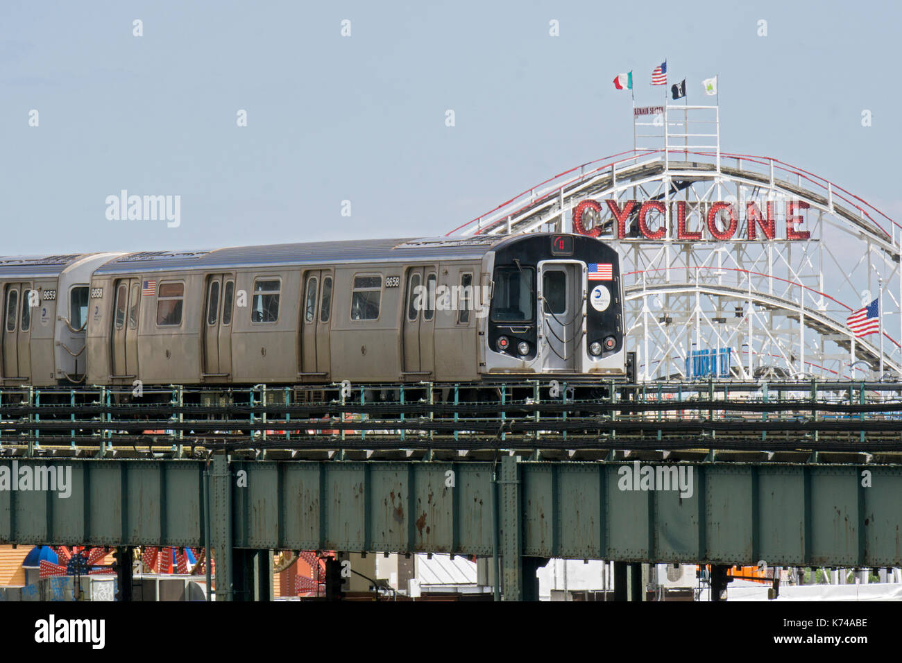 L'elevata Q la linea metropolitana che passa nella parte anteriore del ciclone sul modo per la sua ultima fermata di Coney Island, Brooklyn, New York Foto Stock