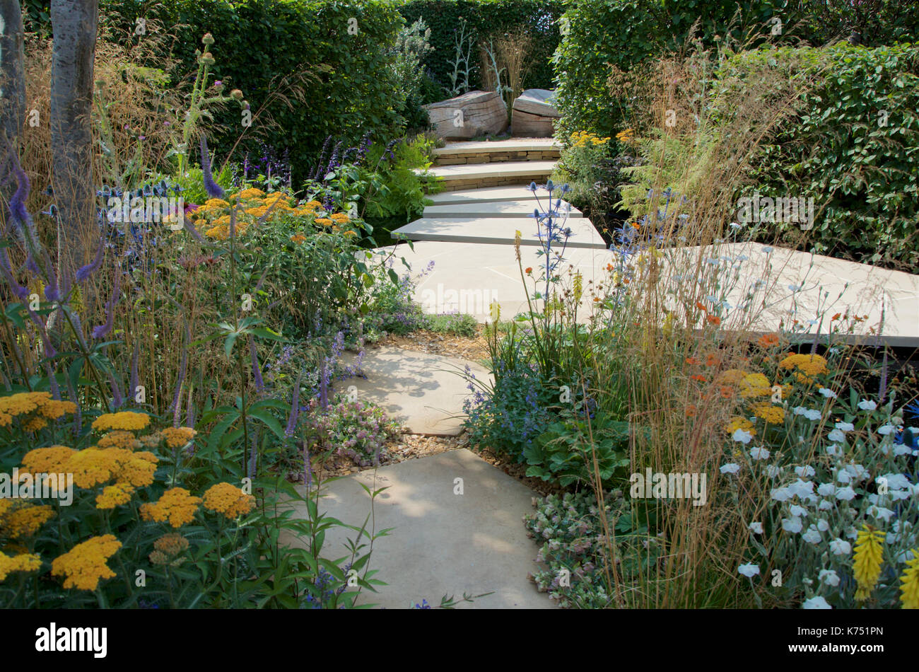 Pavimentazione moderna basata su 'pazzo' di pavimentazione tecnica nel guardare questo spazio giardino disegnato da Andy Lo Storione al RHS Hampton Court Palace Flower Show 2017. Foto Stock