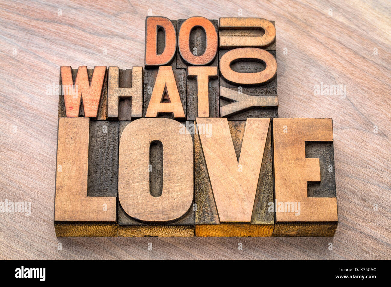 Fare ciò che è amore - ispirazione e motivazione concetto - testo in rilievografia vintage tipo legno Foto Stock