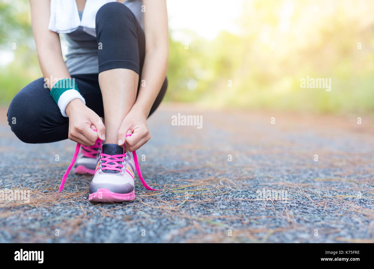 Asia donna runner jogging esercizio solo a perdere grasso peso legatura di lacci delle scarpe. Foto Stock