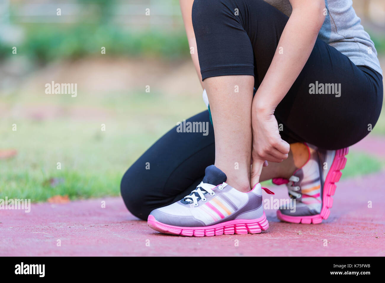 Asia donna runner jogging esercizio solo a perdere grasso peso legatura di lacci delle scarpe Foto Stock