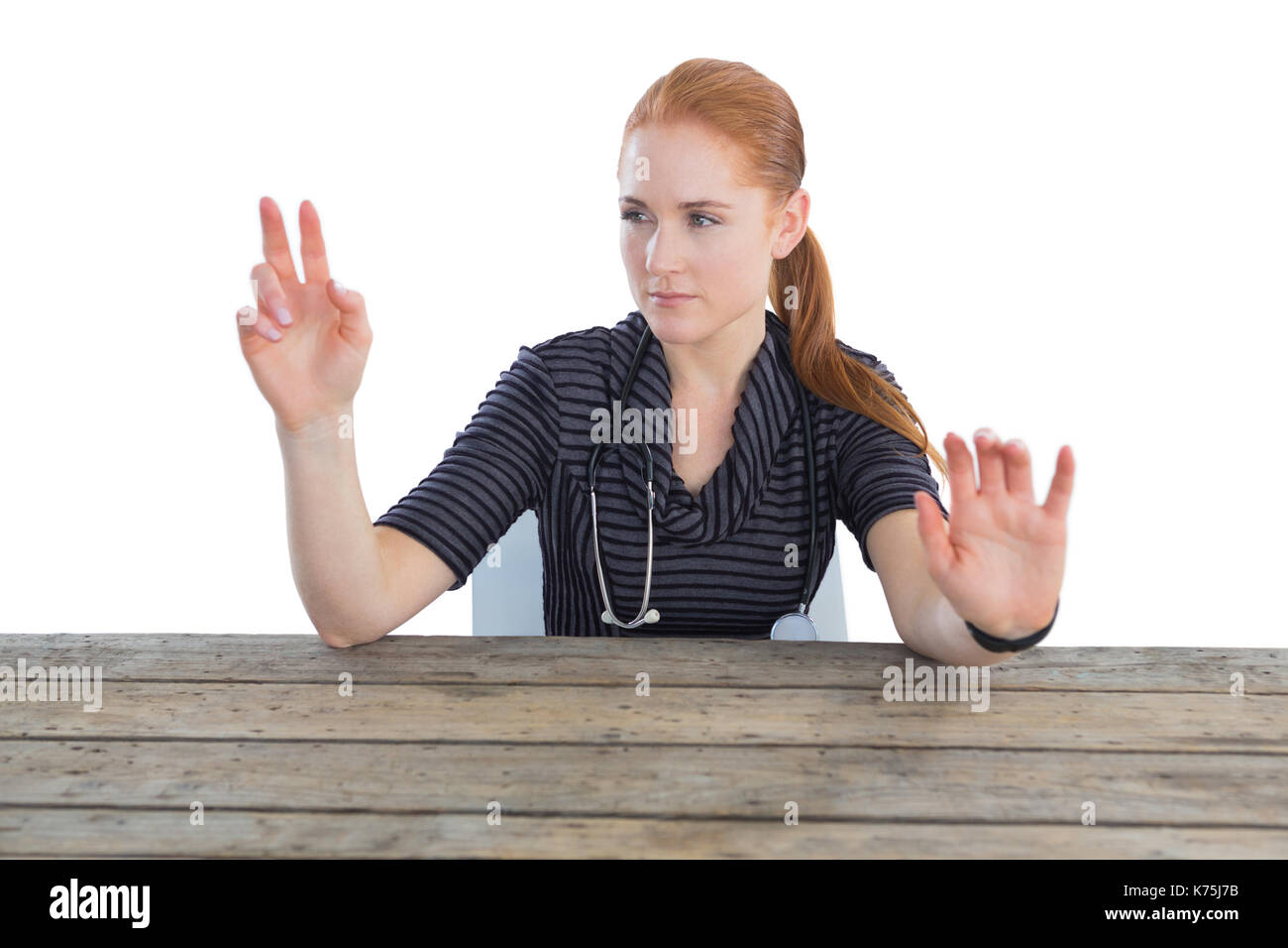 Medico donna toccando lo schermo invisibile a tavola contro backgroound bianco Foto Stock