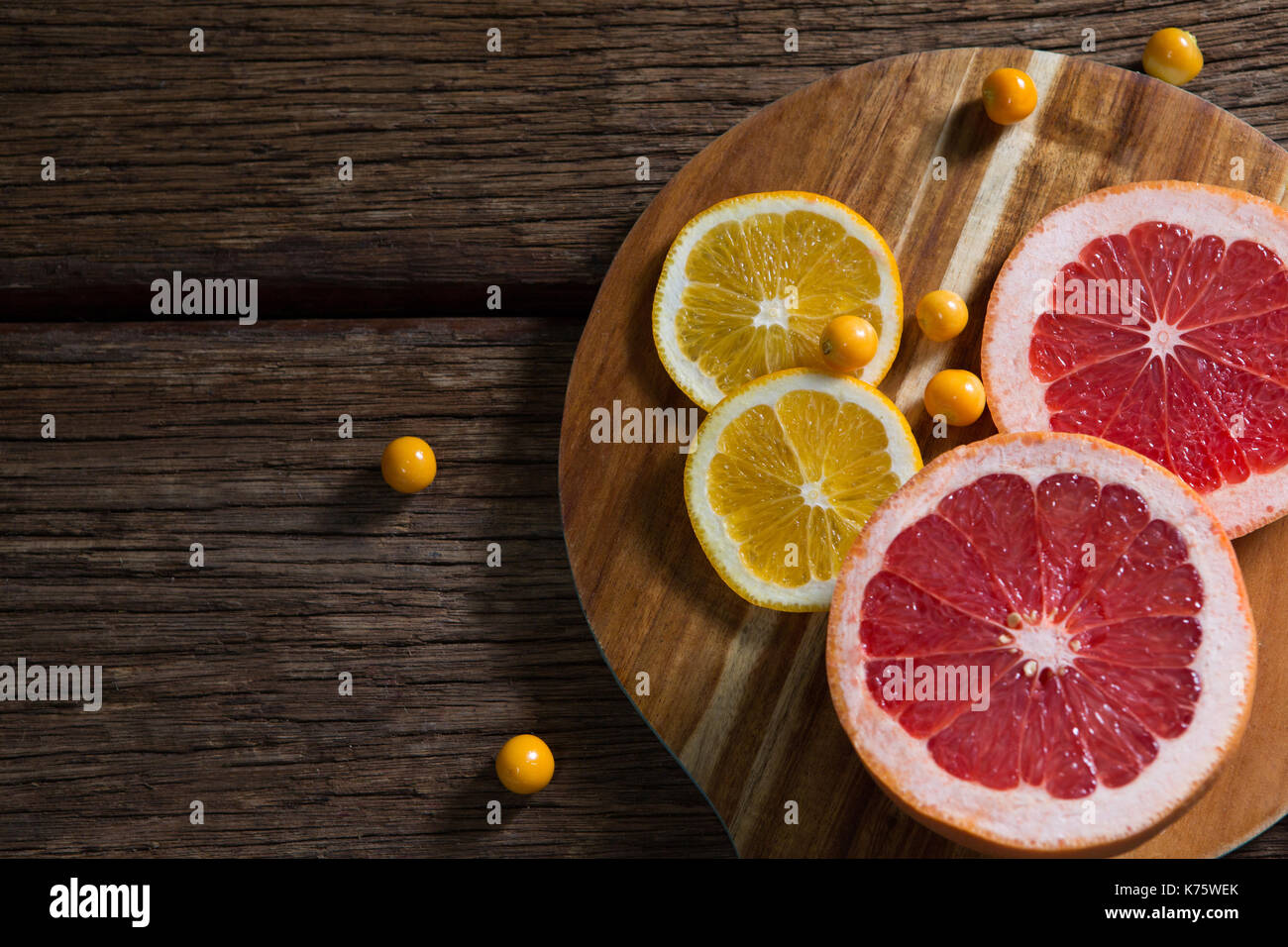Sovraccarico di cape gooseberry con fette di uva e frutta dolce limone sul tavolo Foto Stock