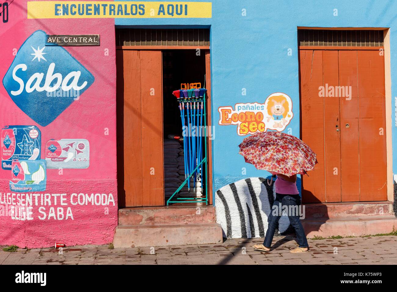 Nicaragua, Esteli provincia, Esteli, donna sotto un ombrello prima di una casa colorata Foto Stock