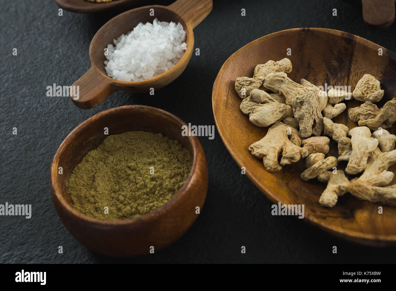 Close-up di essiccato zenzero e coriandolo in polvere su sfondo nero Foto Stock