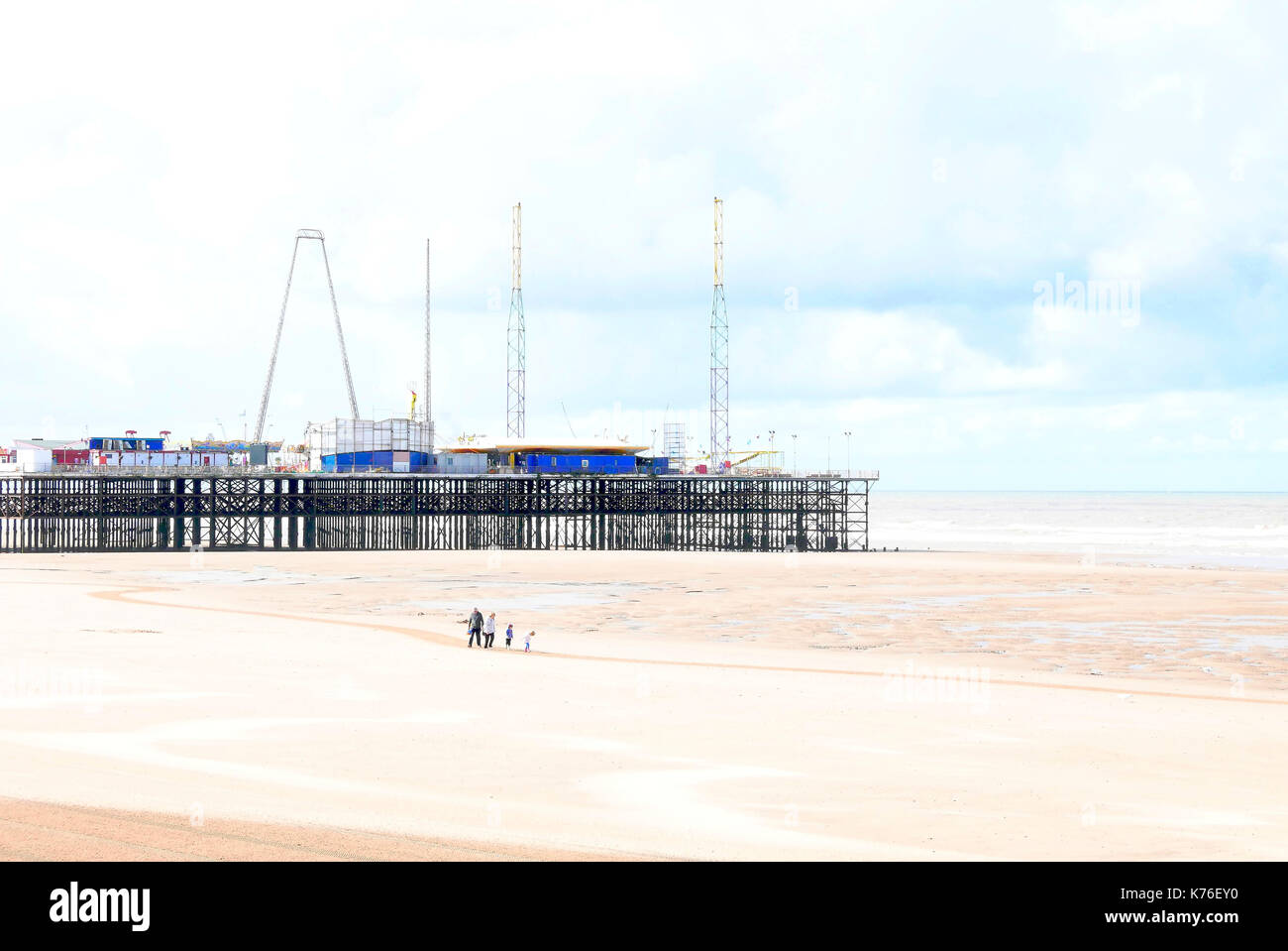 Gruppo di famiglia di quattro sulla spiaggia di fronte al South Pier,Blackpool, Lancashire, Regno Unito Foto Stock