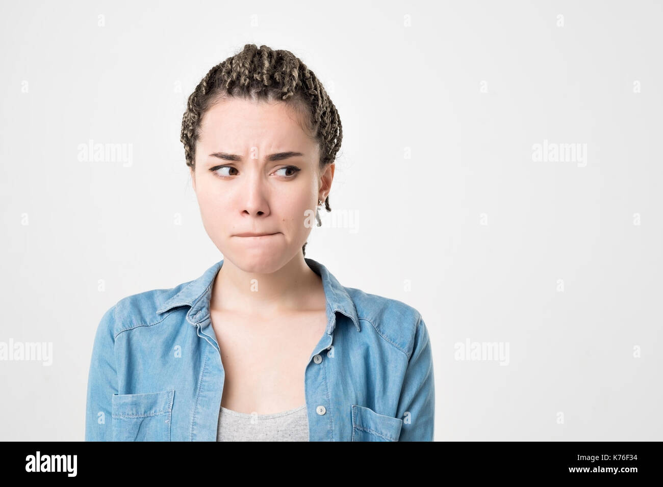 Malinconici dubbia ragazza caucasica con trecce di guardare di traverso, sentirsi sicuri. Ella rendere una decisione importante Foto Stock