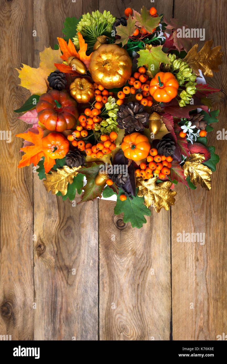 Ringraziamento porta anteriore corona con zucche e foglie di autunno. saluto autunno sfondo con frutti di bosco stagionali e i coni, spazio di copia Foto Stock