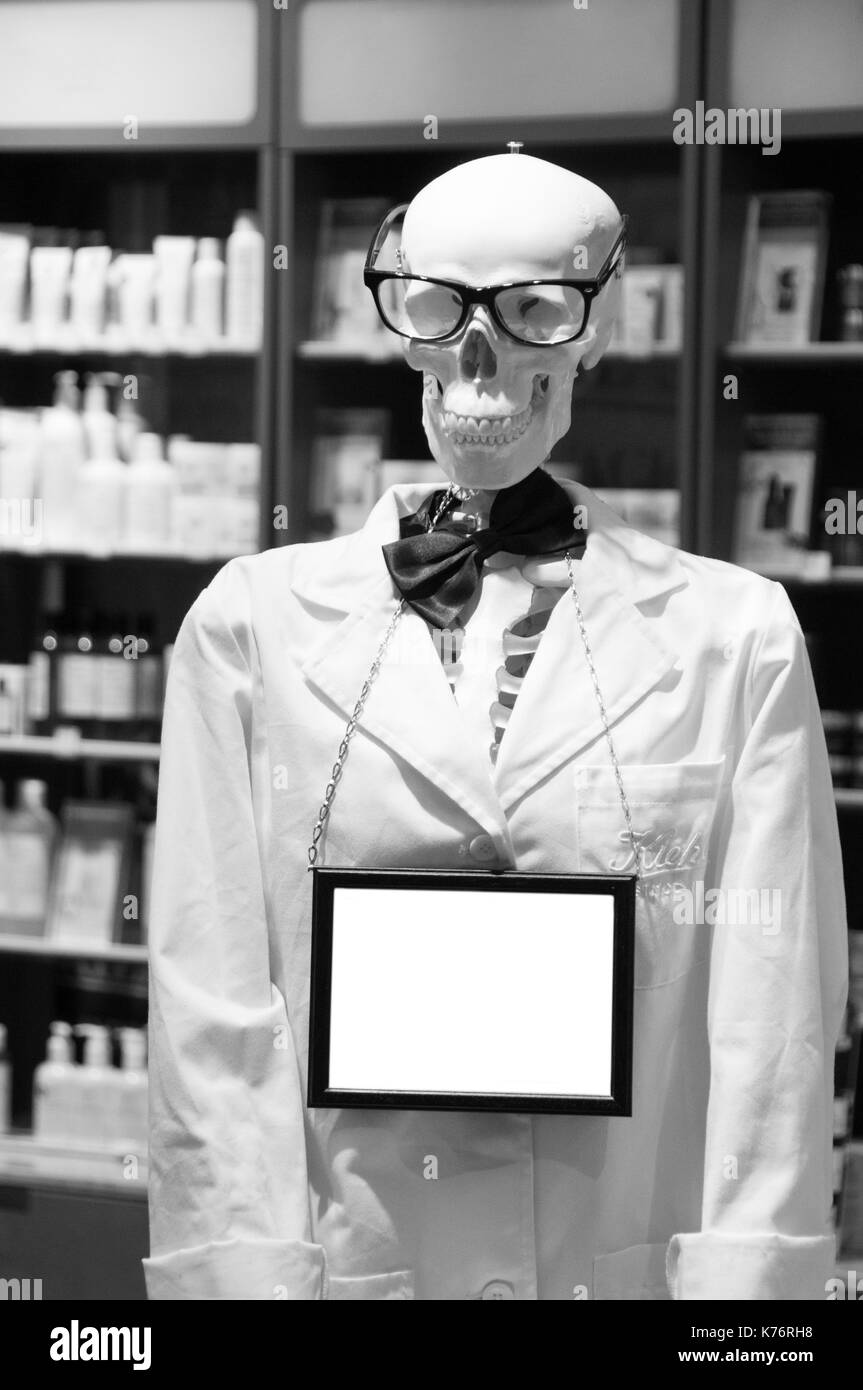 Cranio testa indossando occhiali e bianco laboratorio scientifico cappotto. Foto Stock