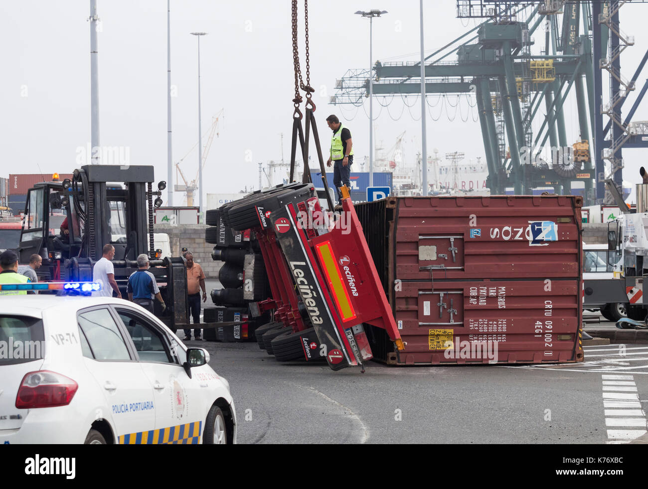 Ribaltato il camion e il rimorchio che trasportano container di spedizione alla rotonda in Spagna Foto Stock