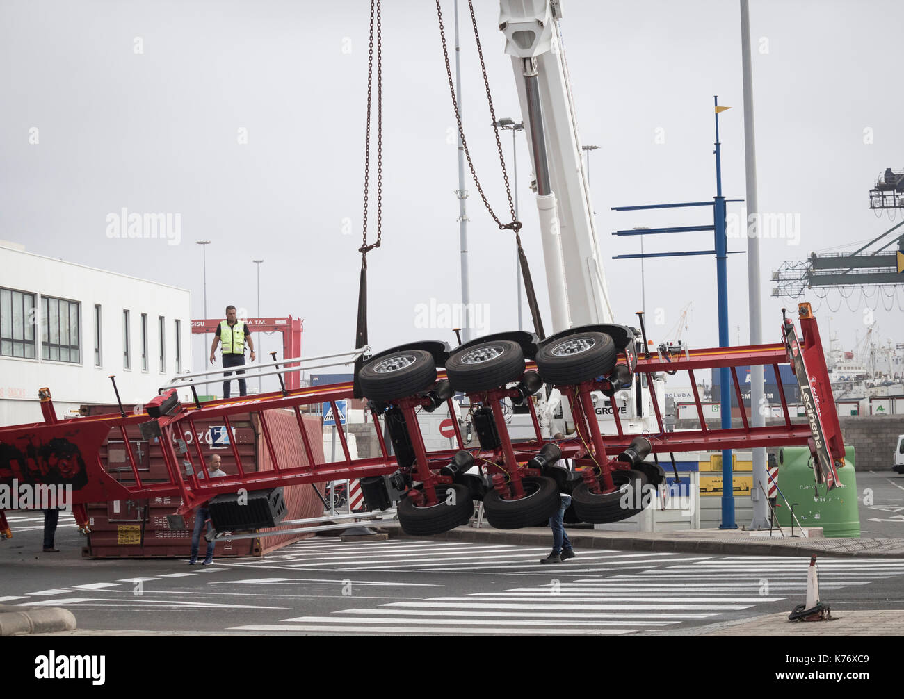 Ribaltato il camion e il rimorchio che trasportano container di spedizione alla rotonda in Spagna Foto Stock