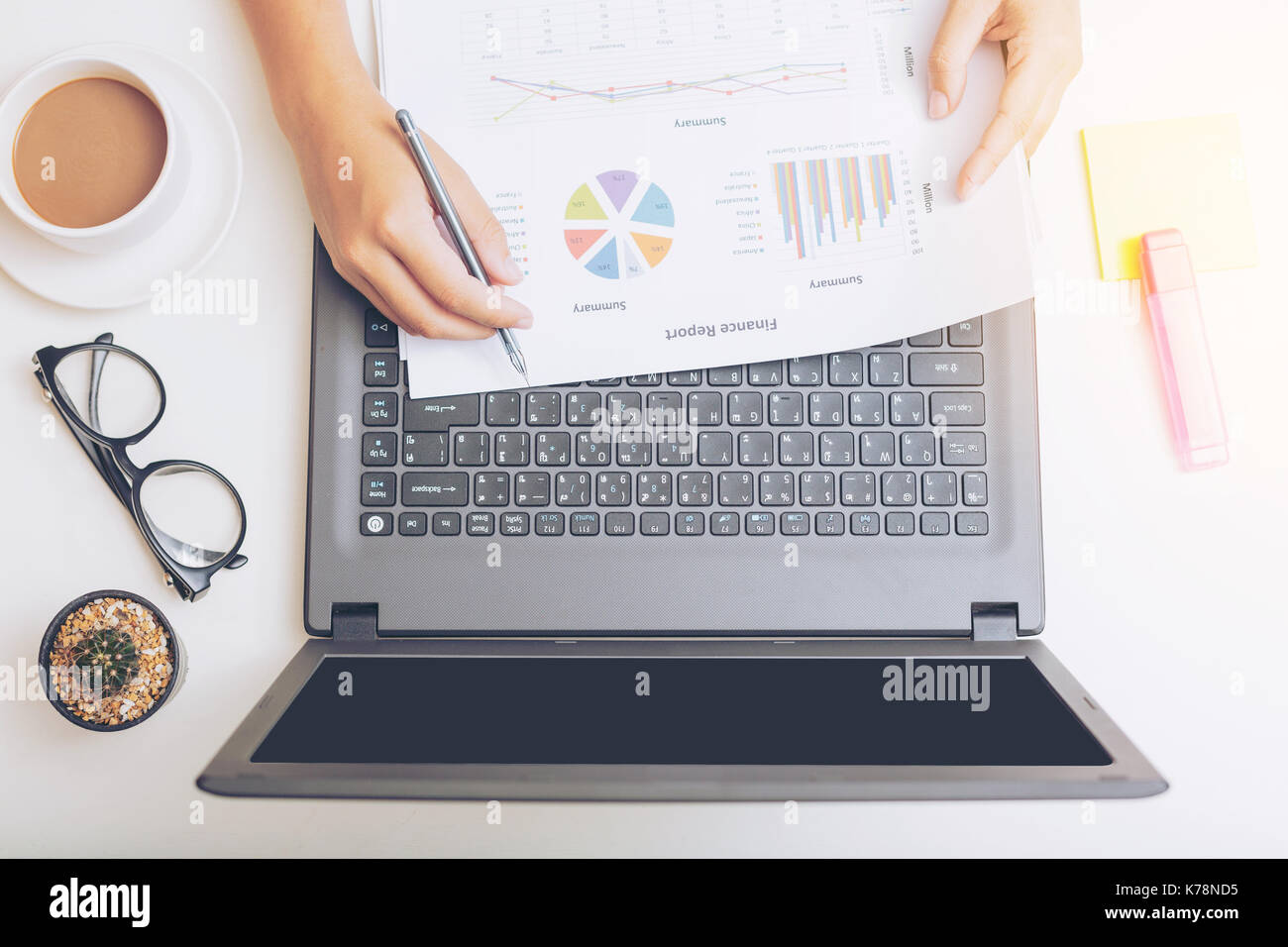 Elevato angolo di visione di un giovane brunette lavorando alla sua scrivania da ufficio con documenti e laptop. imprenditrice lavora su documenti cartacei. Foto Stock