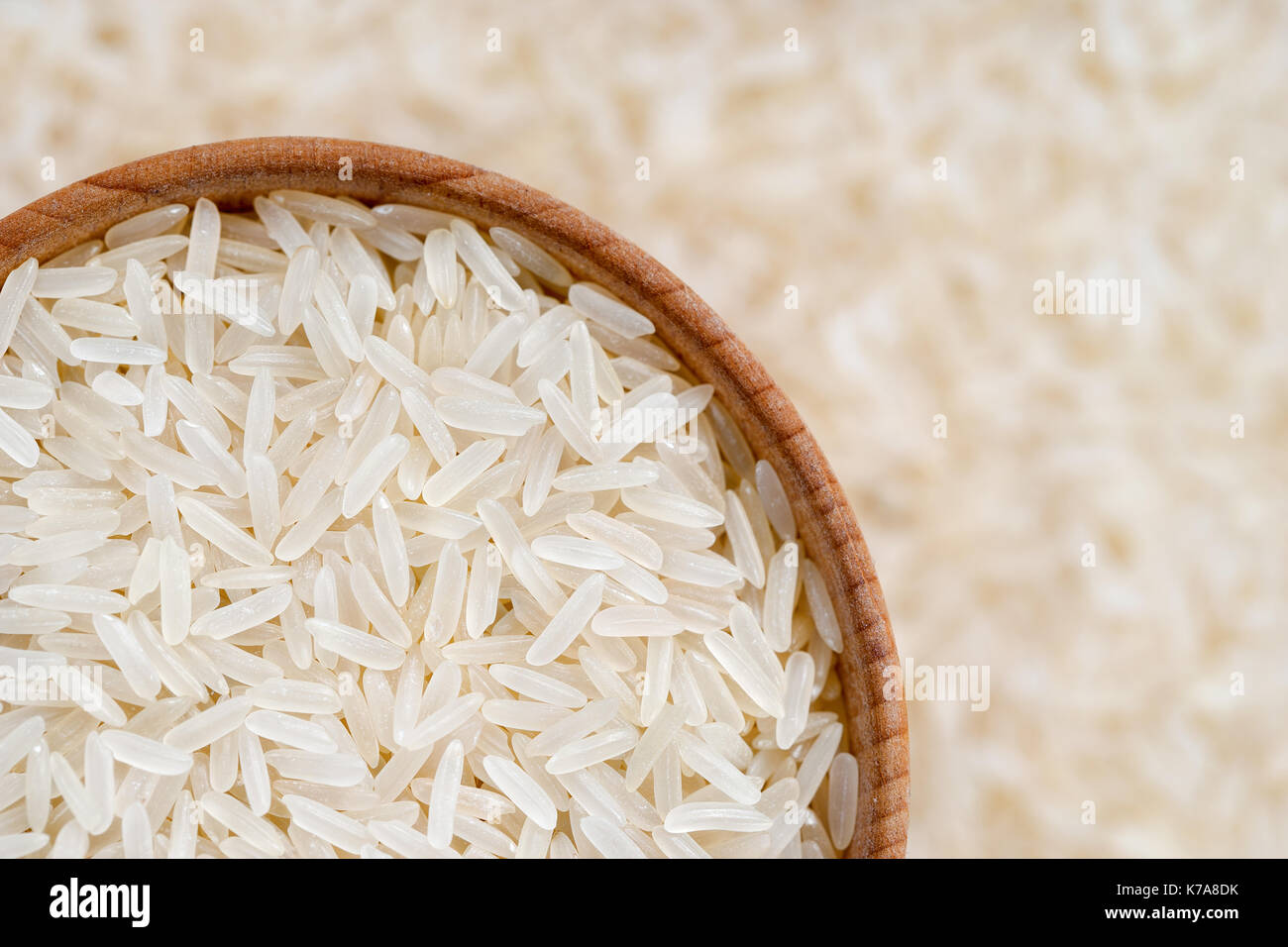 Close up lungo il riso parboiled in ciotola di legno su sfondo sfocato. cibo sano. vista superiore, dei prodotti ad alta risoluzione Foto Stock