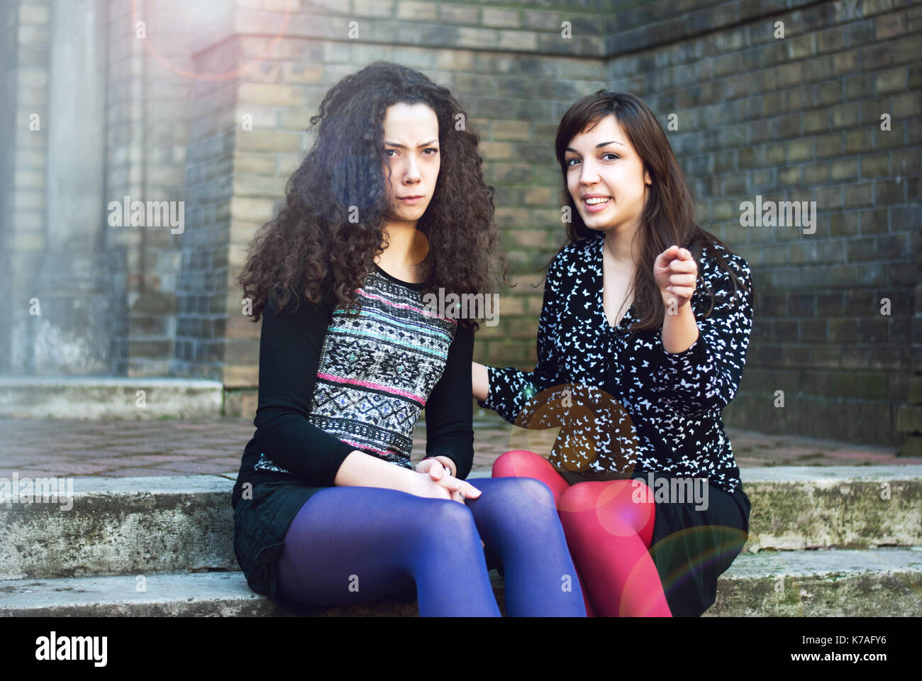 Due sorelle sedere fuori e parlare Foto Stock