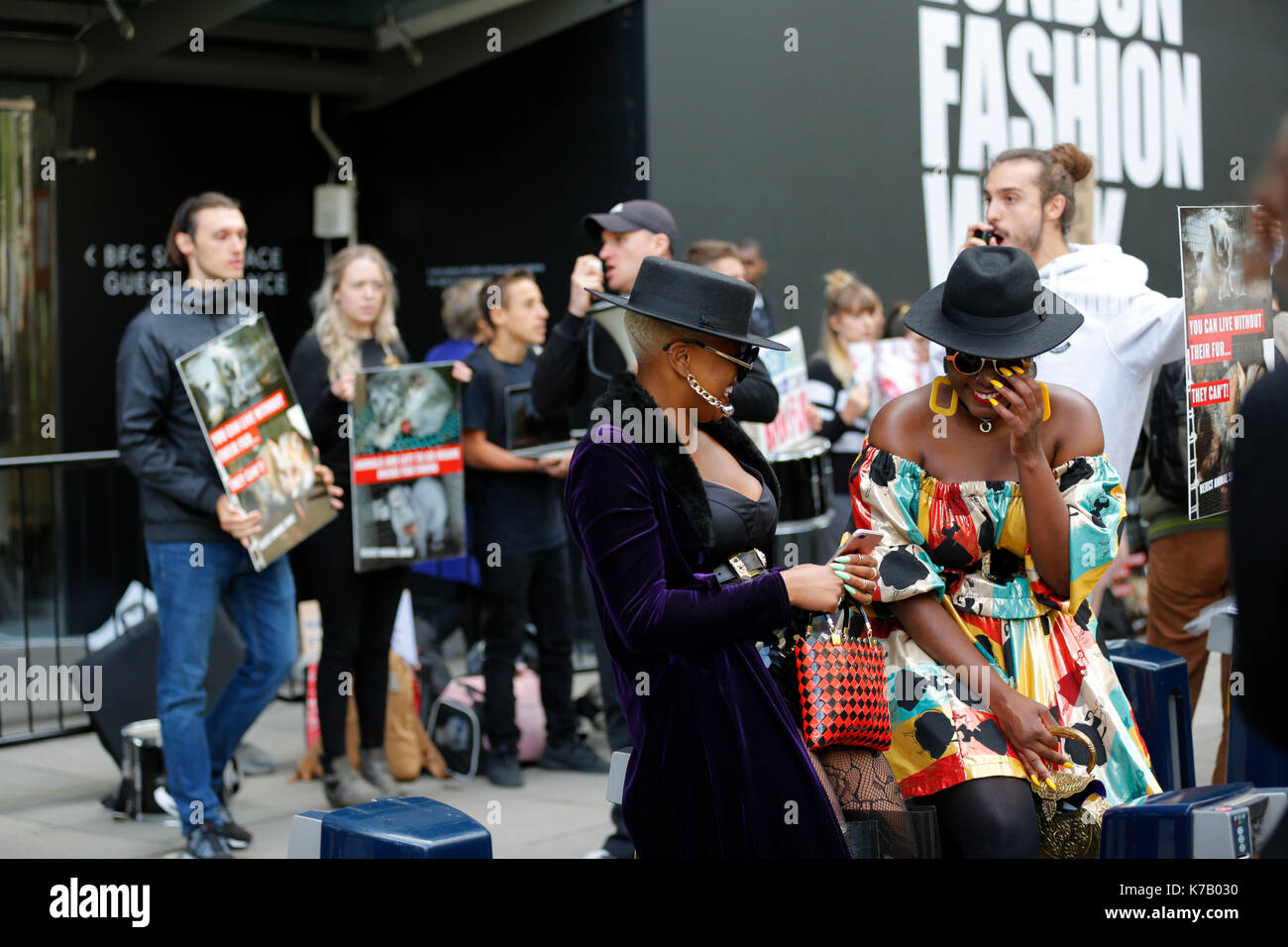 15/09/2017, Londra UK London Fashion Week ss18 e attivisti per i diritti degli animali dimostrando al di fuori del British Fashion Council mostrano lo spazio durante la London Fashion Week ss18. due fashionistas in posa per i fotografi. uno dei fashion girls indossa una pelliccia. di attivisti per i diritti degli animali ha notato che la ragazza indossa una pelliccia e circondato le ragazze con un poster con la crudeltà sugli animali per la pelliccia. Tuttavia due ragazze risatina solo in corrispondenza di attivisti per i diritti degli animali e continuare a posare per telecamere. Foto Stock