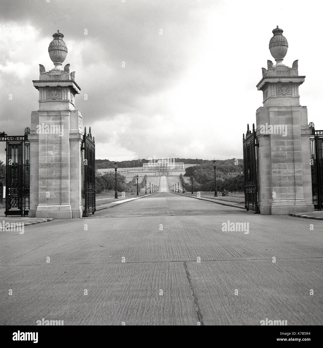 Degli anni Cinquanta, foto storiche dei cancelli e ingresso al parco e della tenuta di Stormont, Belfast, Irlanda del Nord, con il grande edificio alla fine del lungo viale di ingresso progettato in un greco in stile classico, la casa dell'Assemblea dell'Irlanda del Nord (Parlamento) dal 1998. Foto Stock