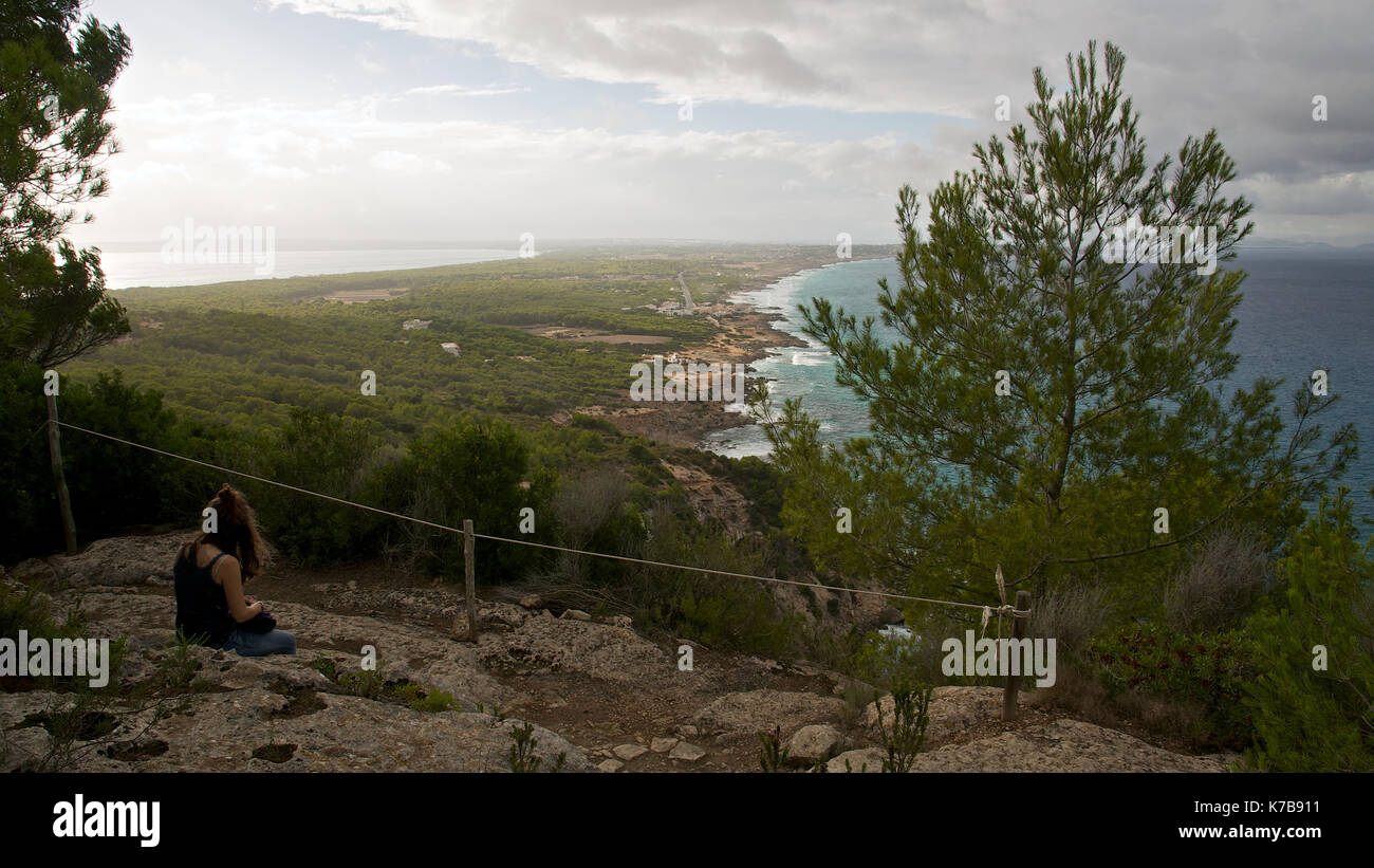 Vista panoramica con una femmina di escursionista in appoggio in un belvedere di Sa Pujada trail a isola di Formentera (Isole Baleari, Spagna) Foto Stock