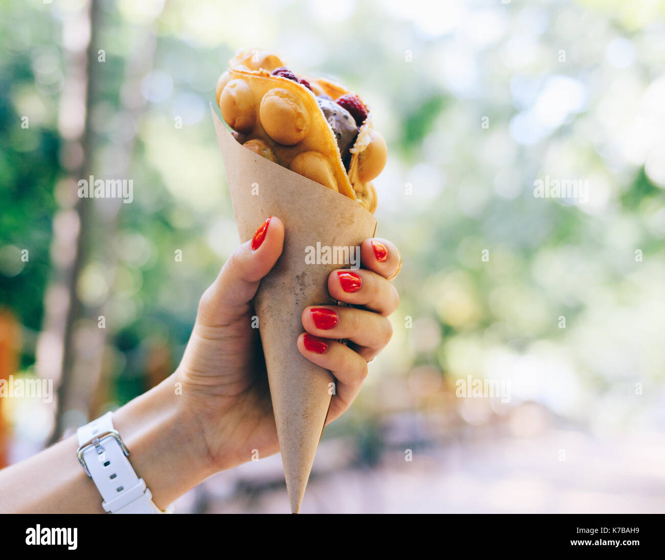 Close-up di fast food in una femmina di mano con red manicure Foto Stock