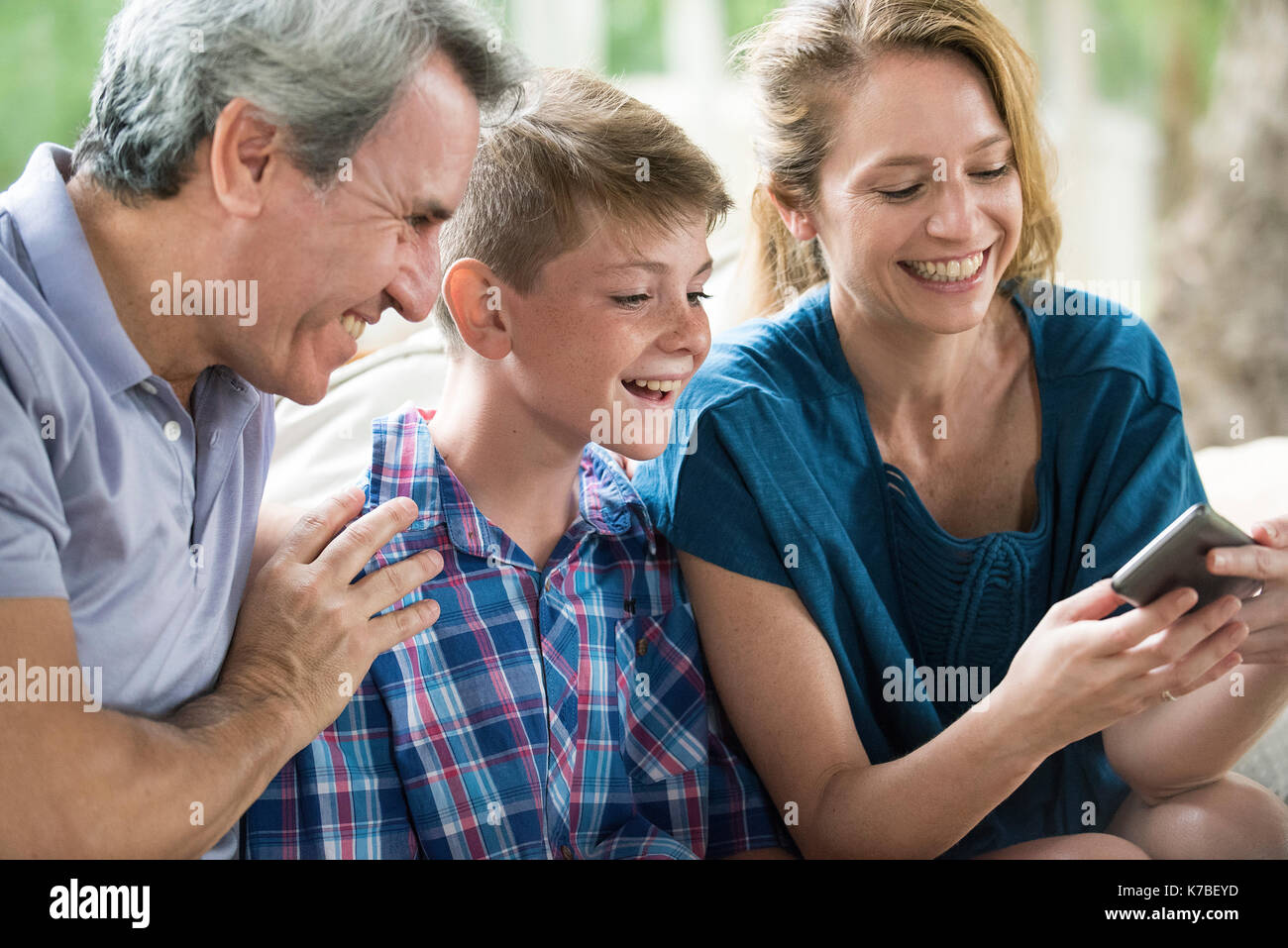 Famiglia guardando insieme allo smartphone Foto Stock